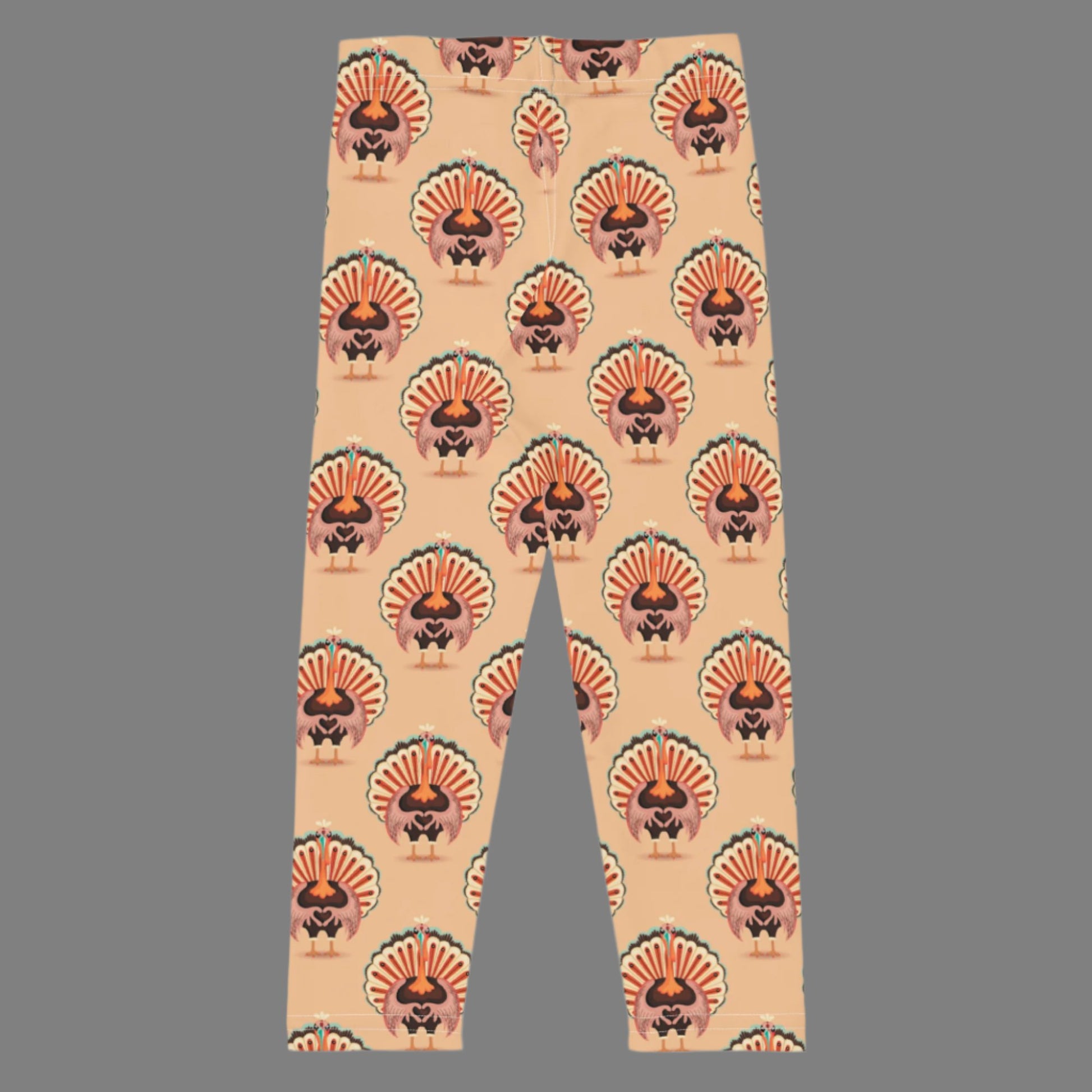 Thanksgiving Turkey Love Toddler leggings. These yoga pants are peach, and have a repeating pattern of turkeys showing the love sign with their hands. These girls child tights make a great gift, or a family matching outfit for the Turkey Trot! by jaecrece