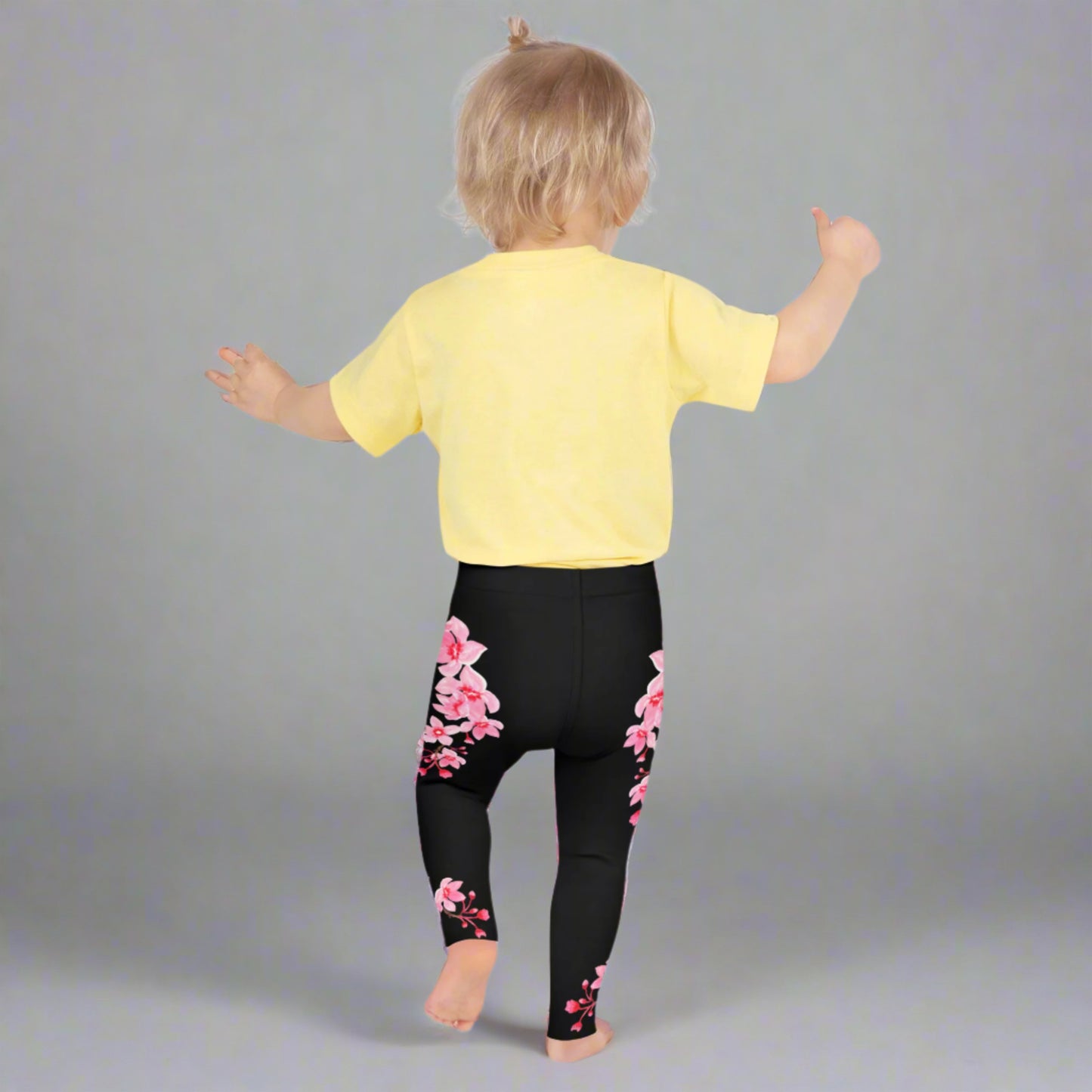 Image: Japanese Cherry Blossom Girls and Toddler Leggings, in sizes 2T, 3t, 4T, 5T, 6, 6X and 7. Black leggings with a swirl of Japanese cherry blossoms going down the outside of each leg. Elastic, soft, and durable with vibrant colors. Part of a matching collection for younger children and women, each pair is precision-cut and hand-sewn for a perfect fit.