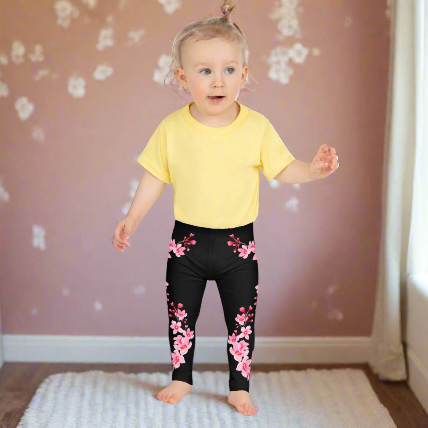 Image: Japanese Cherry Blossom Girls and Toddler Leggings, in sizes 2T, 3t, 4T, 5T, 6, 6X and 7. Black leggings with a swirl of Japanese cherry blossoms going down the outside of each leg. Elastic, soft, and durable with vibrant colors. Part of a matching collection for younger children and women, each pair is precision-cut and hand-sewn for a perfect fit.