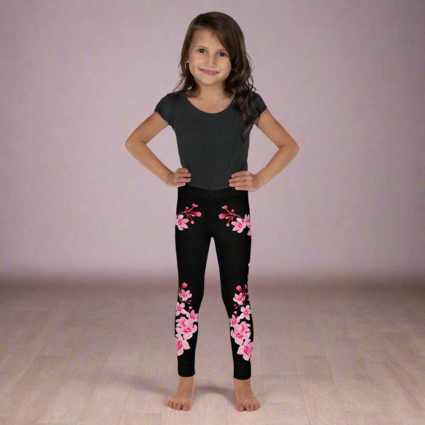 Image: Japanese Cherry Blossom Girls and Toddler Leggings, in sizes 2T, 3t, 4T, 5T, 6, 6X and 7. Black leggings with a swirl of Japanese cherry blossoms going down the outside of each leg. Elastic, soft, and durable with vibrant colors. Part of a matching collection for younger children and women, each pair is precision-cut and hand-sewn for a perfect fit.
