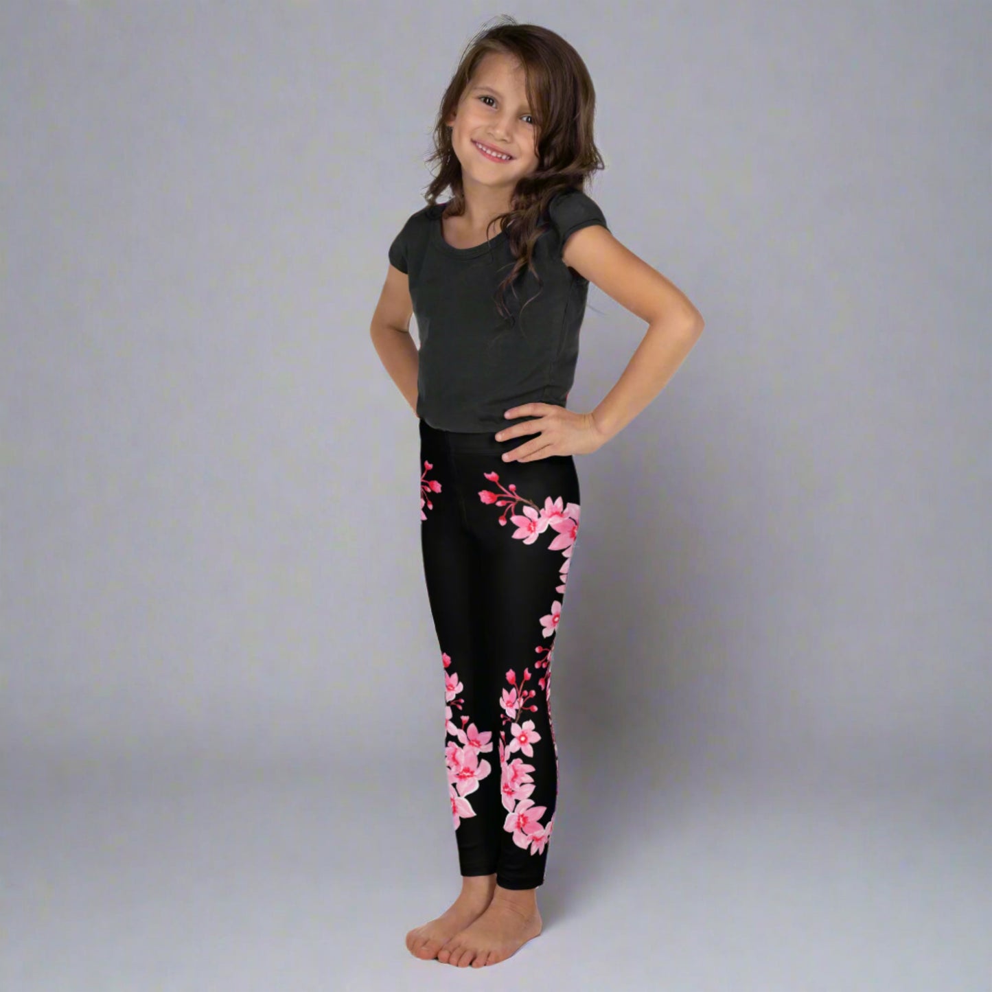 Image: Japanese Cherry Blossom Girls and Toddler Leggings, in sizes 2T, 3t, 4T, 5T, 6, 6X and 7. Black leggings with a swirl of Japanese cherry blossoms going down the outside of each leg. Elastic, soft, and durable with vibrant colors. Part of a matching collection for younger children and women, each pair is precision-cut and hand-sewn for a perfect fit.