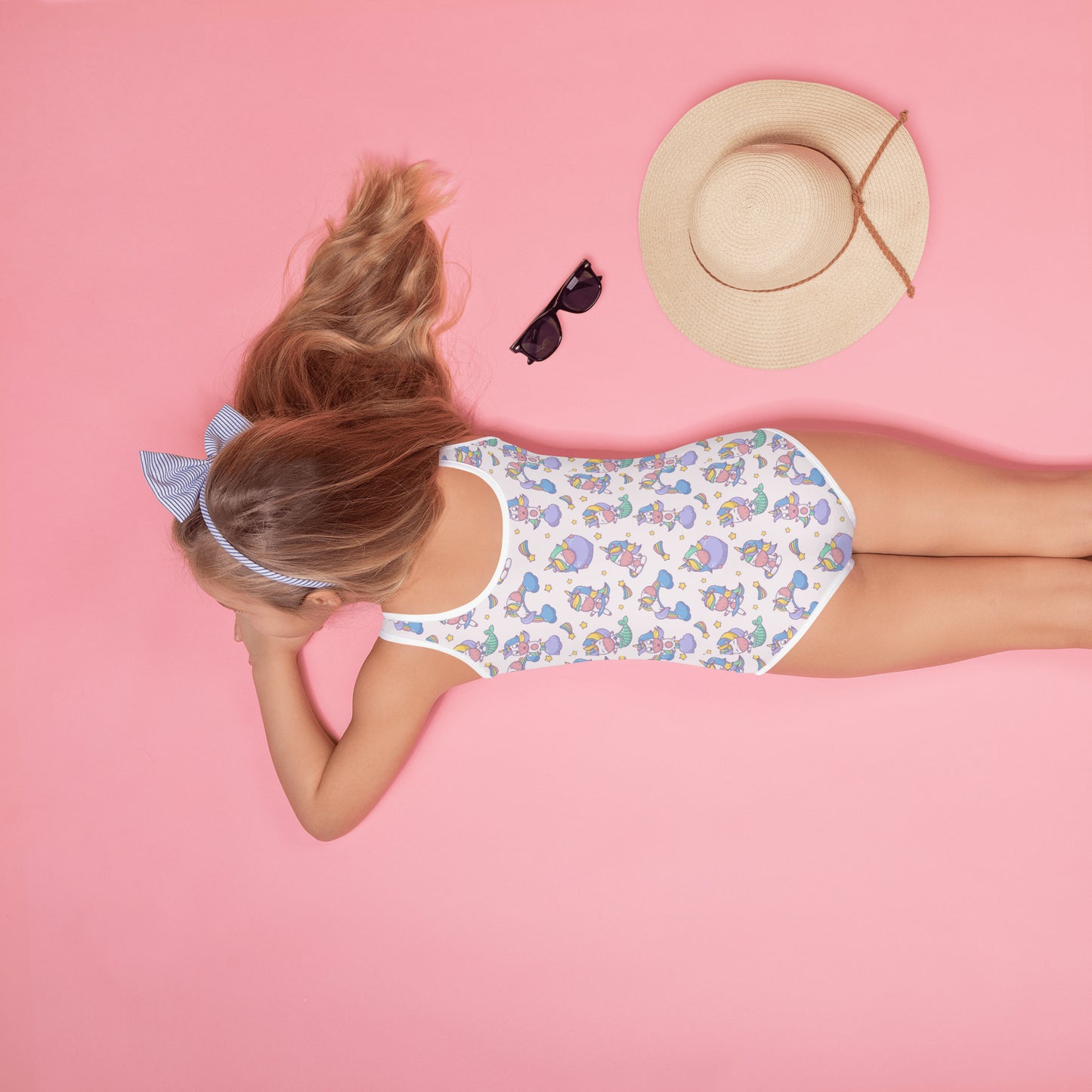 Image: Child bathing suit in toddler and girl sizes 2T-7, featuring a pink background with a cute Kawaii whimsical creature pattern of unicorn mermaids, rainbows and stars. Perfect as a Christmas gift, birthday present, or for your childs next pool party, by jaecrece
