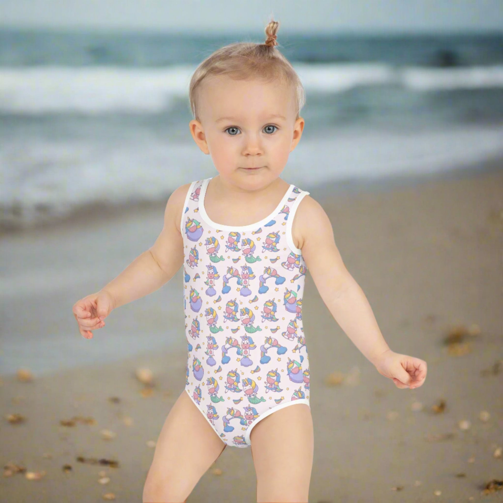 Image: Child bathing suit in toddler and girl sizes 2T-7, featuring a pink background with a cute Kawaii whimsical creature pattern of unicorn mermaids, rainbows and stars. Perfect as a Christmas gift, birthday present, or for your childs next pool party, by jaecrece