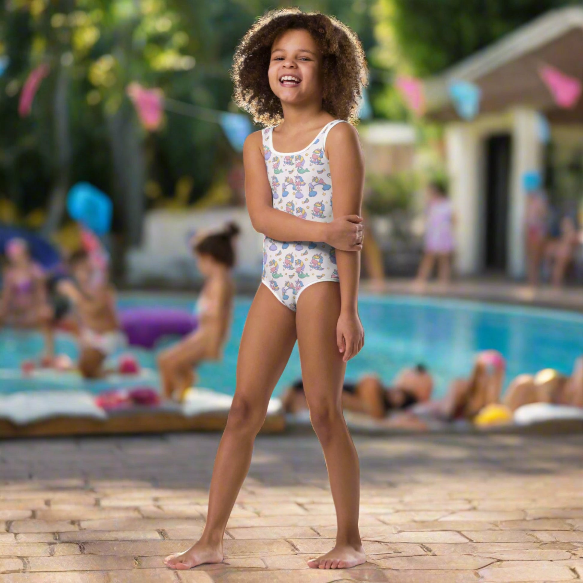 Image: Child bathing suit in toddler and girl sizes 2T-7, featuring a pink background with a cute Kawaii whimsical creature pattern of unicorn mermaids, rainbows and stars. Perfect as a Christmas gift, birthday present, or for your childs next pool party, by jaecrece