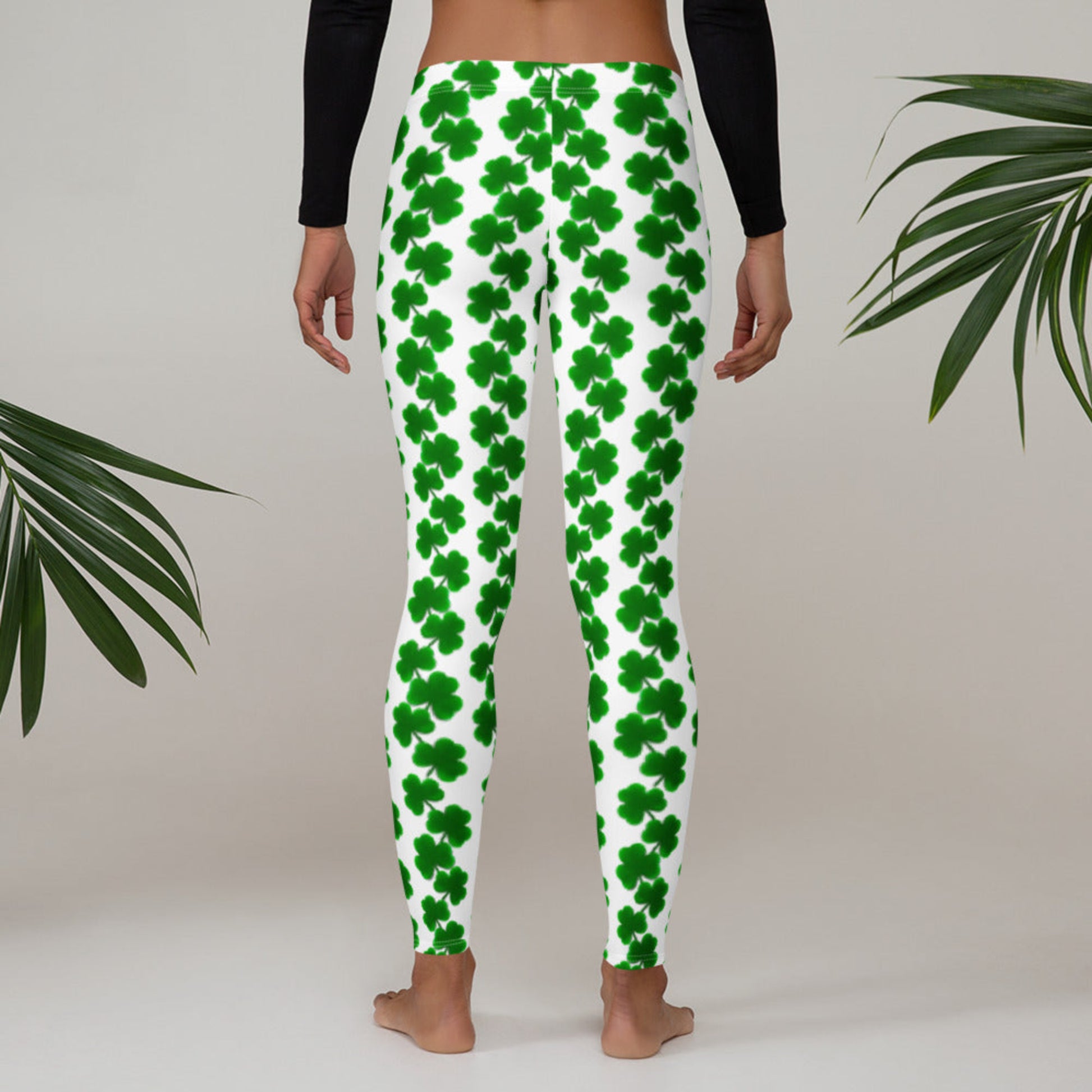 Image: St Patricks Day Clover Leggings for women. The yoga pants are white with a green shamrock pattern. Also available in sizes for toddlers, girls, teens and tweens, These women’s St. Patrick’s Day leggings feature an all-over shamrock design on a white background with a mid-rise waistband and full-length legs. Designed for comfort and flexibility, they’re ideal for festive holiday looks, casual wear, or matching with kids for a coordinated family outfit. Available in sizes XS to XL, these fun leggings a
