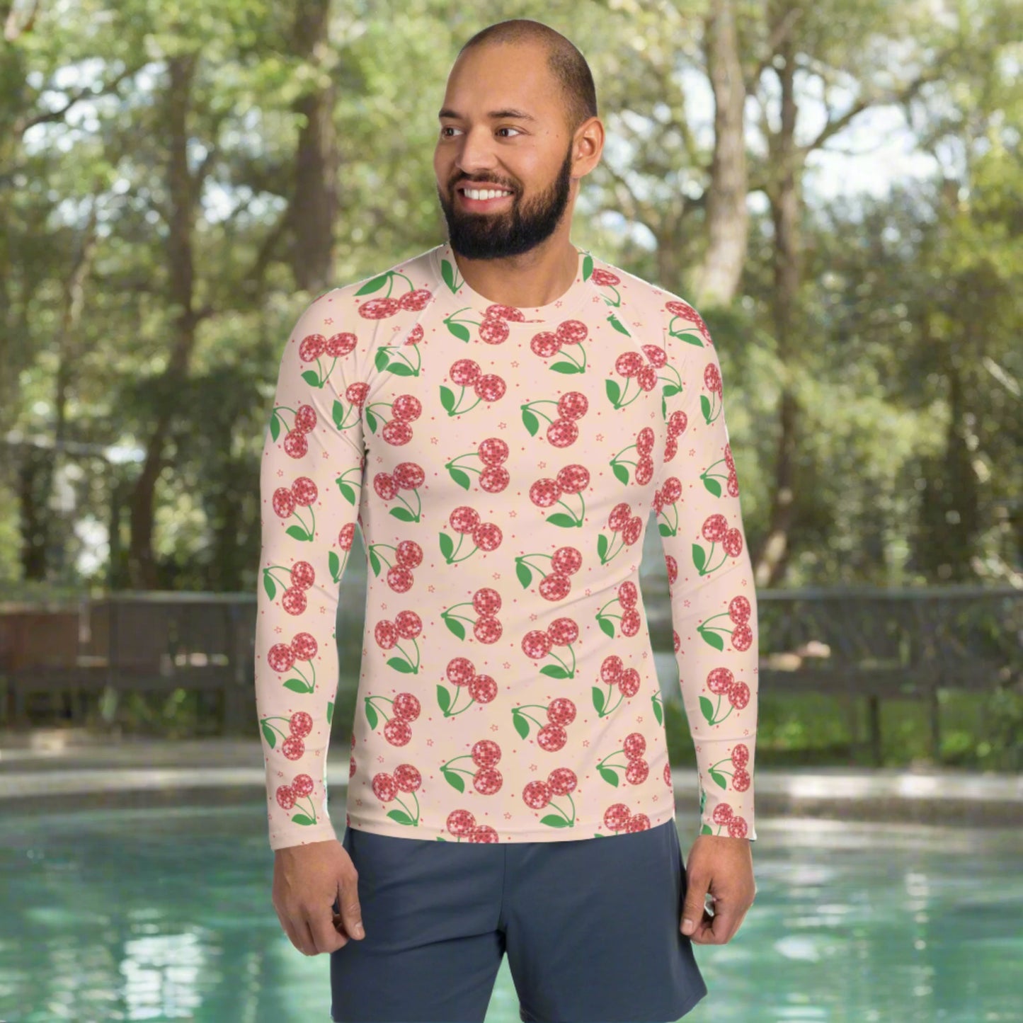 Image: Disco Cherries Mens Rash Guard, part of a family matching swimwear collection. This rash guard has a pink background, with a pattern of red disco ball cherries and stars, by jaecrece