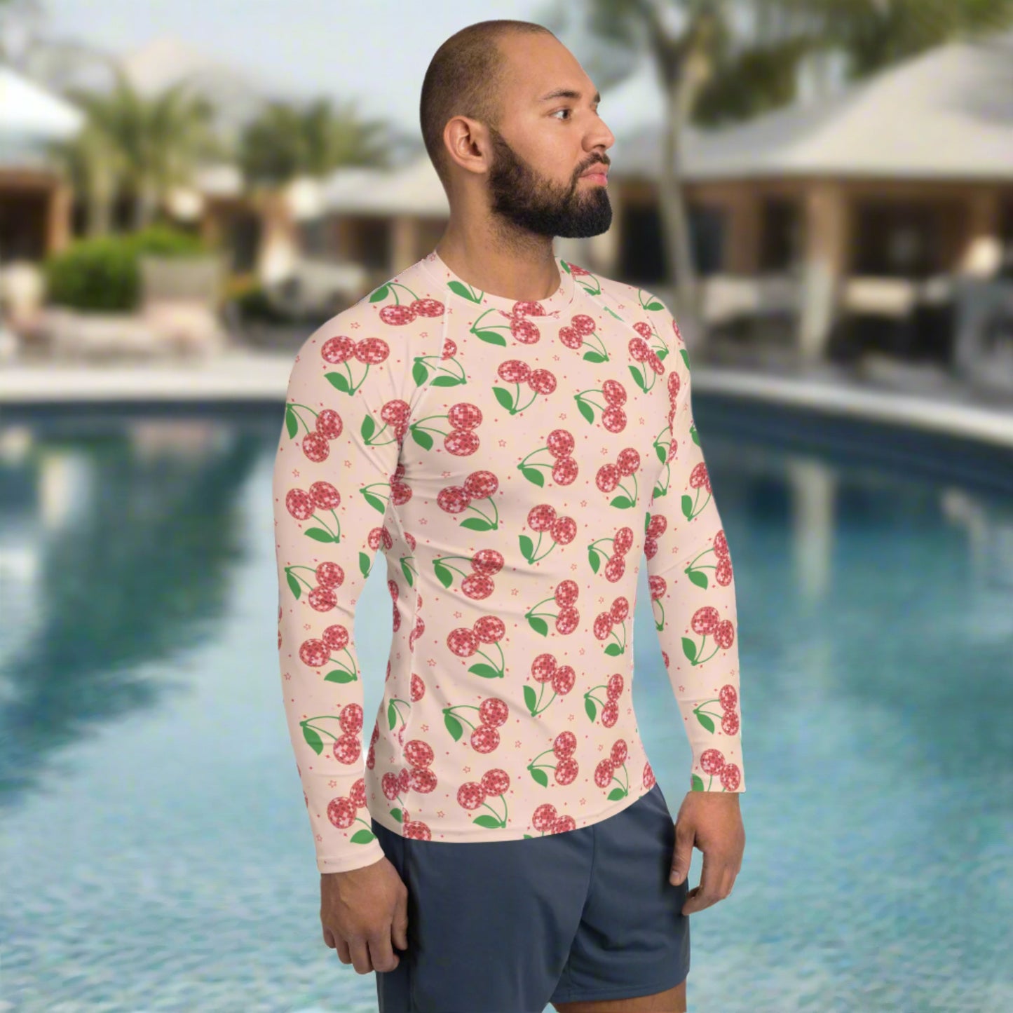Image: Disco Cherries Mens Rash Guard, part of a family matching swimwear collection. This rash guard has a pink background, with a pattern of red disco ball cherries and stars, by jaecrece