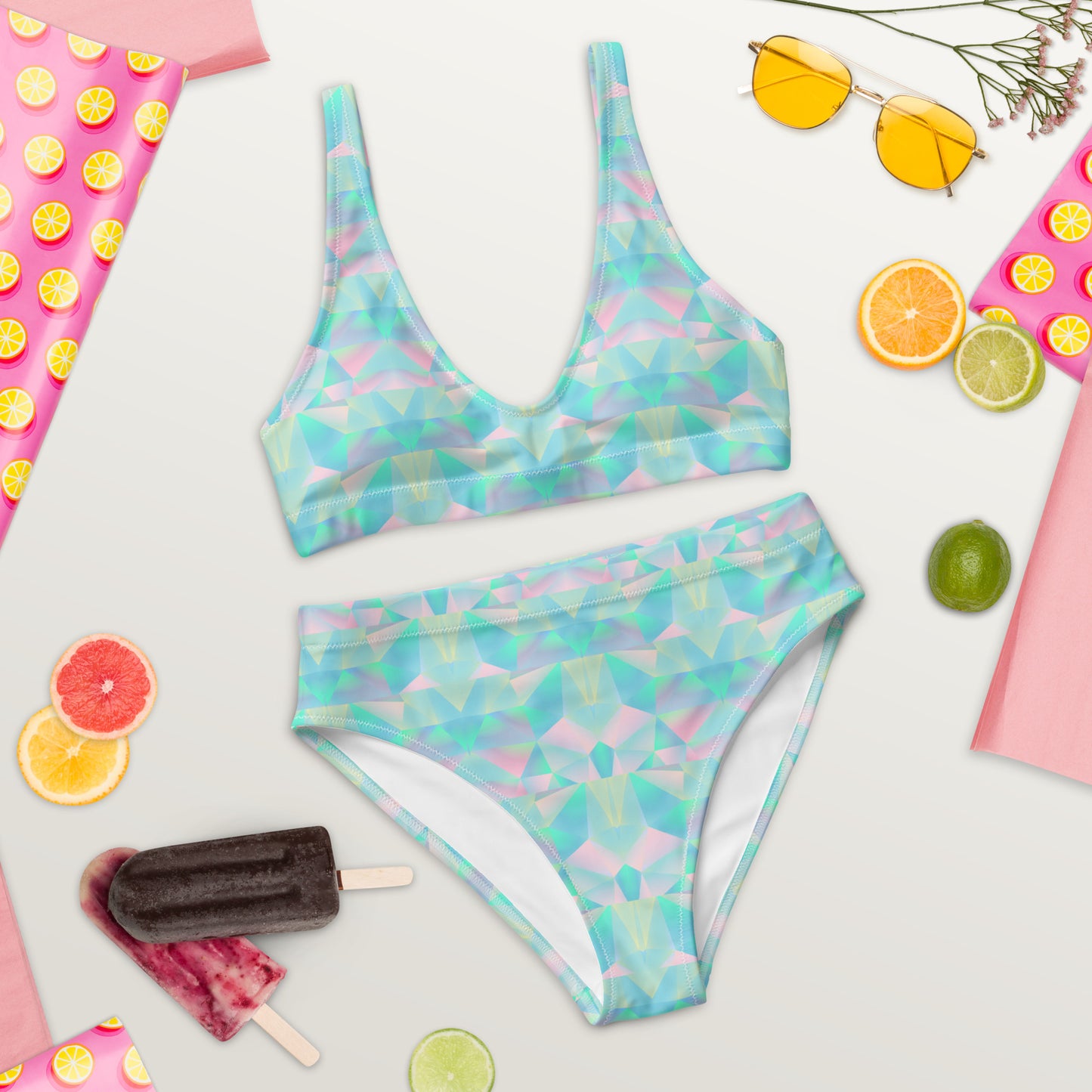 Image: This pastel prism two piece bikini is a must-have for beach lovers who adore sustainable fashion. The high waist fit provides a flattering silhouette, while the teal, blue, and pink geometric pattern adds a modern twist. Made from recycled materials, this eco-conscious swimsuit is perfect for pool parties, ocean adventures, or simply soaking up the sun in effortless style and comfort, by jaecrece.