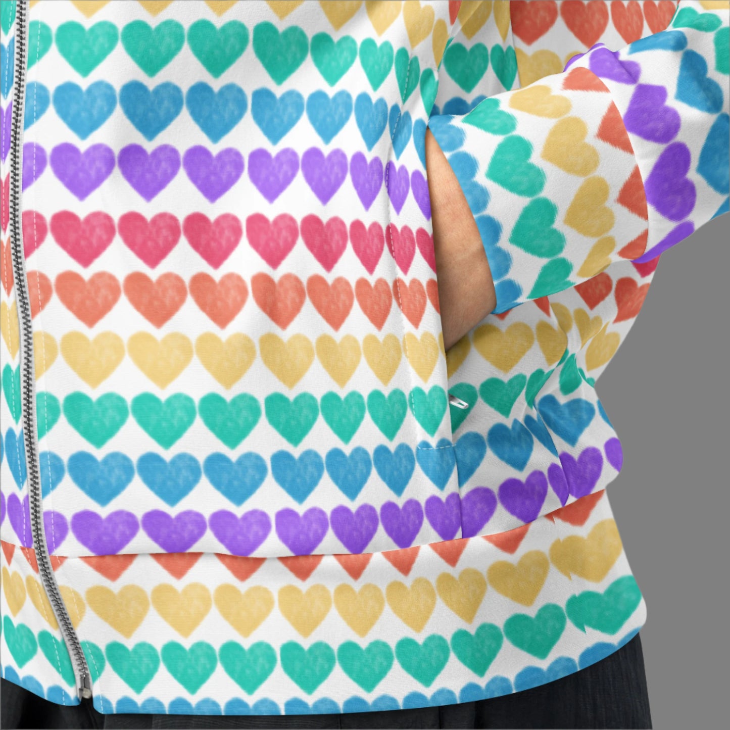 Image: Rainbow Hearts Unisex Track Jacket. This lightweight athletic coat has rows of hearts in the color of the rainbow. Featuring rows of colorful hearts on a crisp white background, this rainbow track jacket is available in sizes 2XS–6XL. Whether you’re layering it for a parade, party, or just a walk around the neighborhood, it makes a bold statement of pride and positivity. Great for matching family sets or solo style moments.