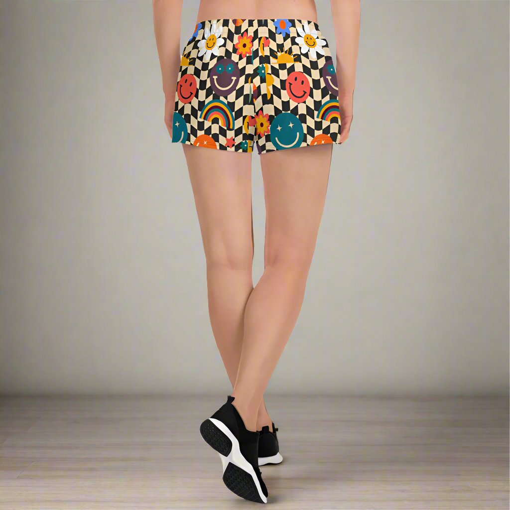 Smiley Face Checkerboard Ladies Athletic Shorts. These cute shorts feature a black and khaki checkerboard background, with smiley face, rainbow and daisy graphics. by jaecrece.com