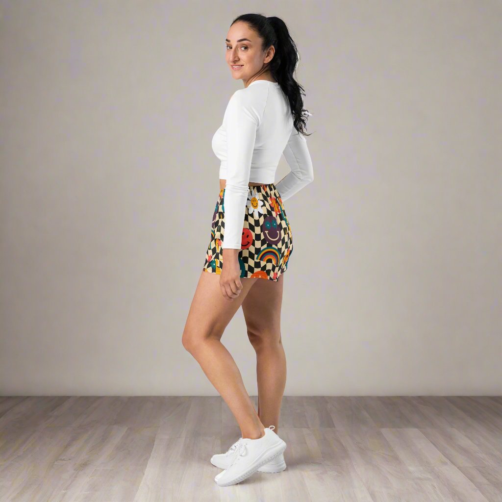 Smiley Face Checkerboard Ladies Athletic Shorts. These cute shorts feature a black and khaki checkerboard background, with smiley face, rainbow and daisy graphics. by jaecrece.com