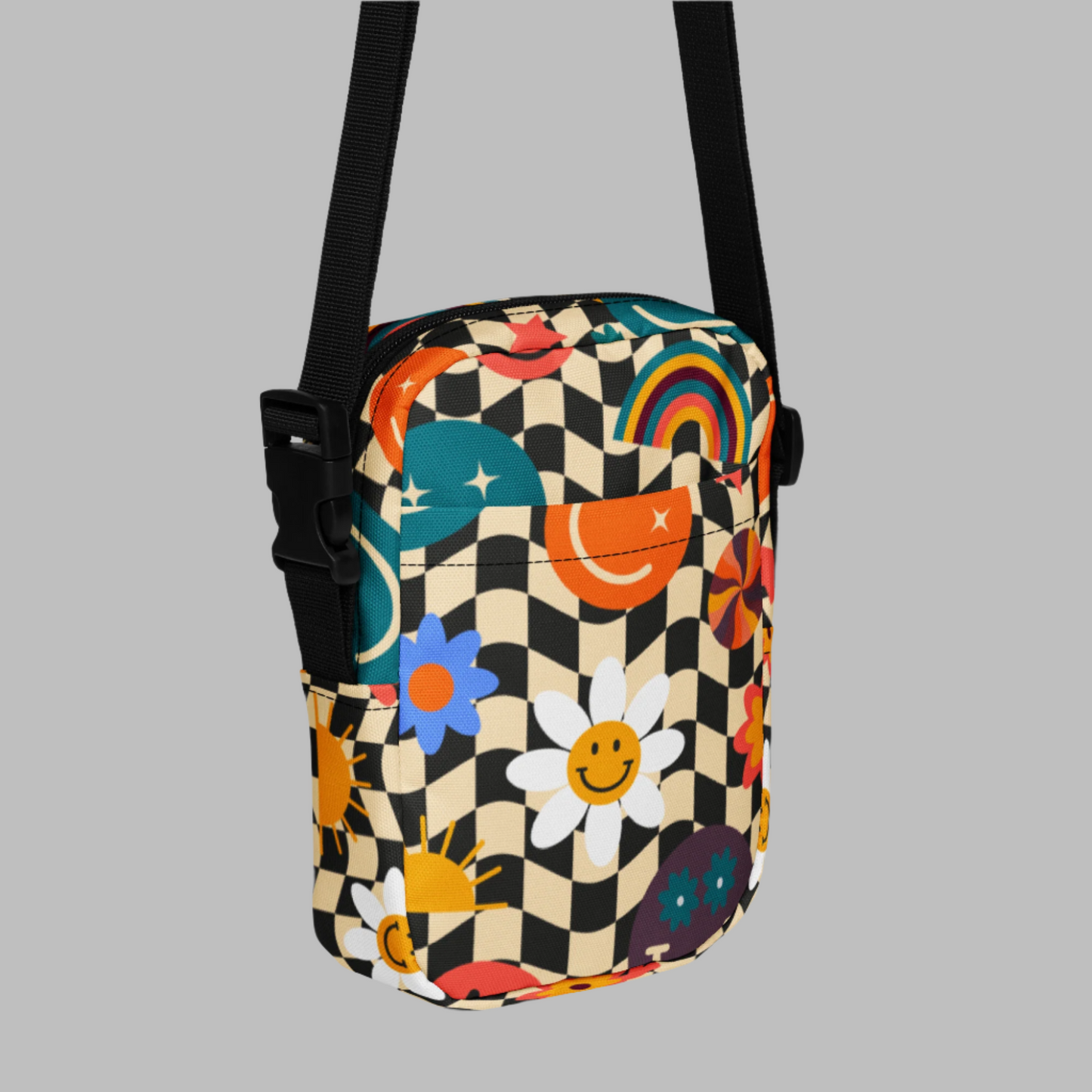 Smiley Face Checkerboard Utility Crossbody Bag. This cute small canvas carryall is eco friendly, and features a black and khaki checkerboard background, with smiley face, rainbow and daisy graphics. It is perfect for hiking, vacations and festivals, and can be worn across the chest, or on the hips/ waist. By jaecrece.com