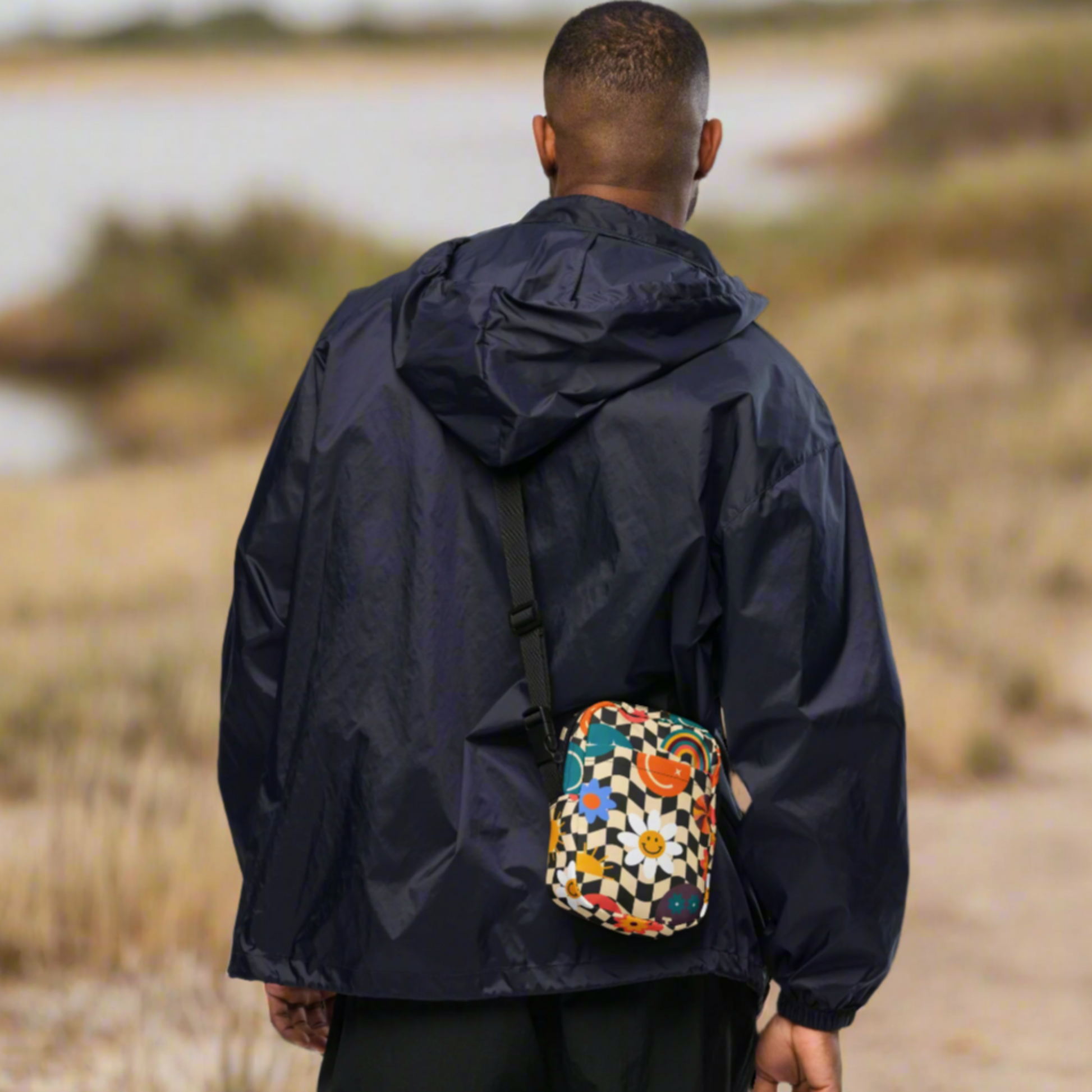 Smiley Face Checkerboard Utility Crossbody Bag. This cute small canvas carryall is eco friendly, and features a black and khaki checkerboard background, with smiley face, rainbow and daisy graphics. It is perfect for hiking, vacations and festivals, and can be worn across the chest, or on the hips/ waist. By jaecrece.com