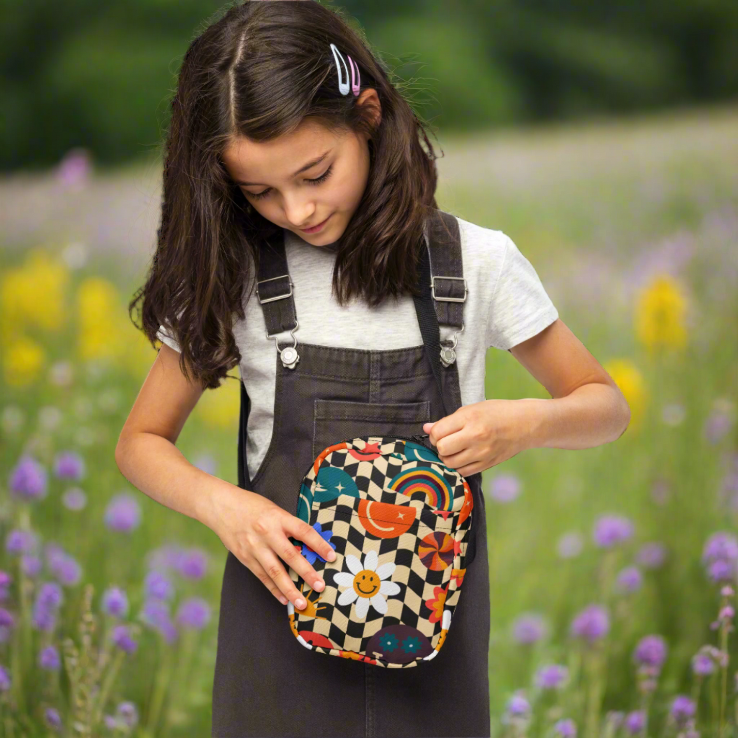 Smiley Face Checkerboard Utility Crossbody Bag. This cute small canvas carryall is eco friendly, and features a black and khaki checkerboard background, with smiley face, rainbow and daisy graphics. It is perfect for hiking, vacations and festivals, and can be worn across the chest, or on the hips/ waist. By jaecrece.com