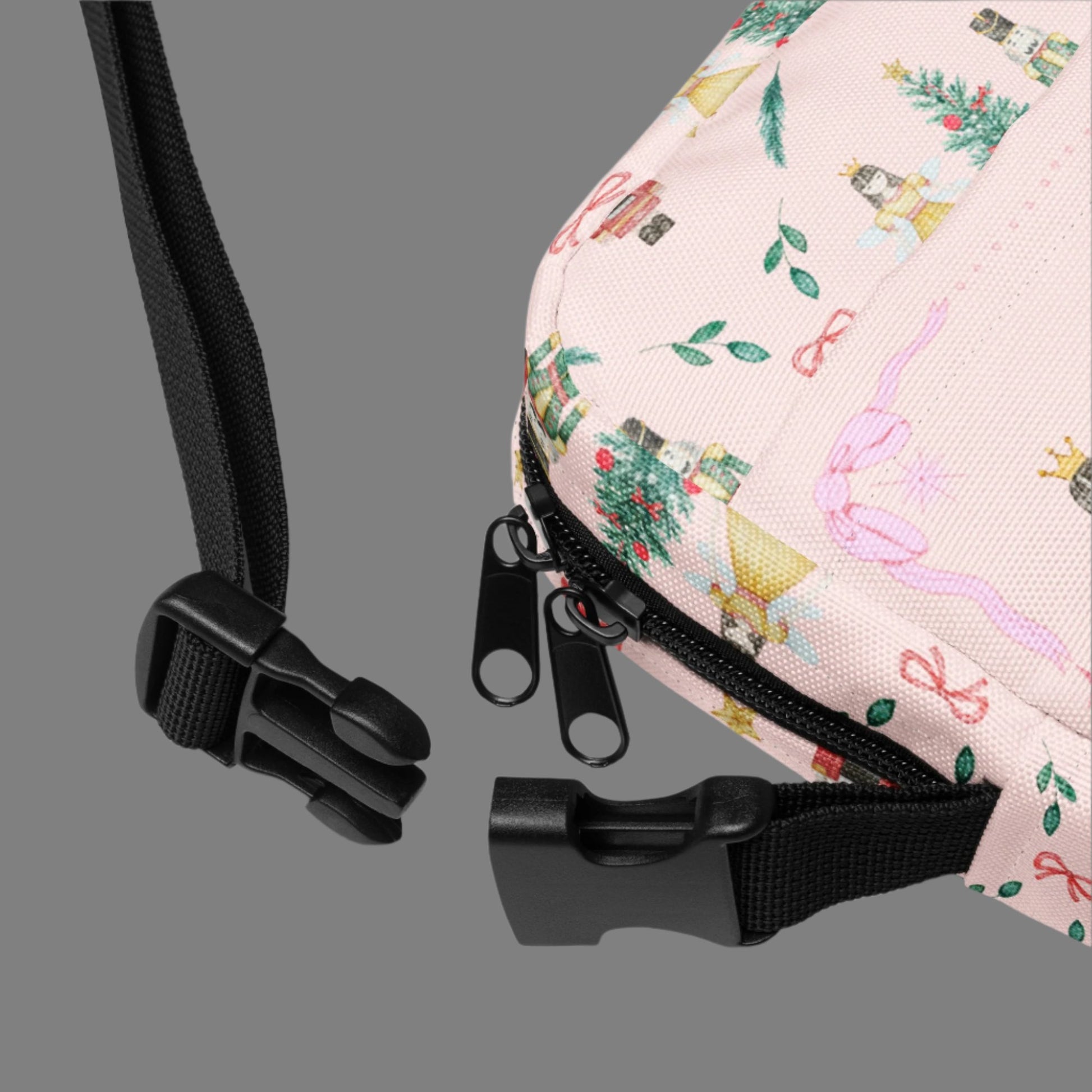 Image: Pink Coquette Nutcracker Utility Crossbody bag. The front of this small mini tote has a Christmas tree, Nutcracker, Sugarplum Fairy, Rocking Horse and a holiday present The rest of the purse is covered in a pattern of ribbons, garland, and Nutcrackers. May be worn across the waist/ hips, across the chest or as a mini backpack, by jaecrece
