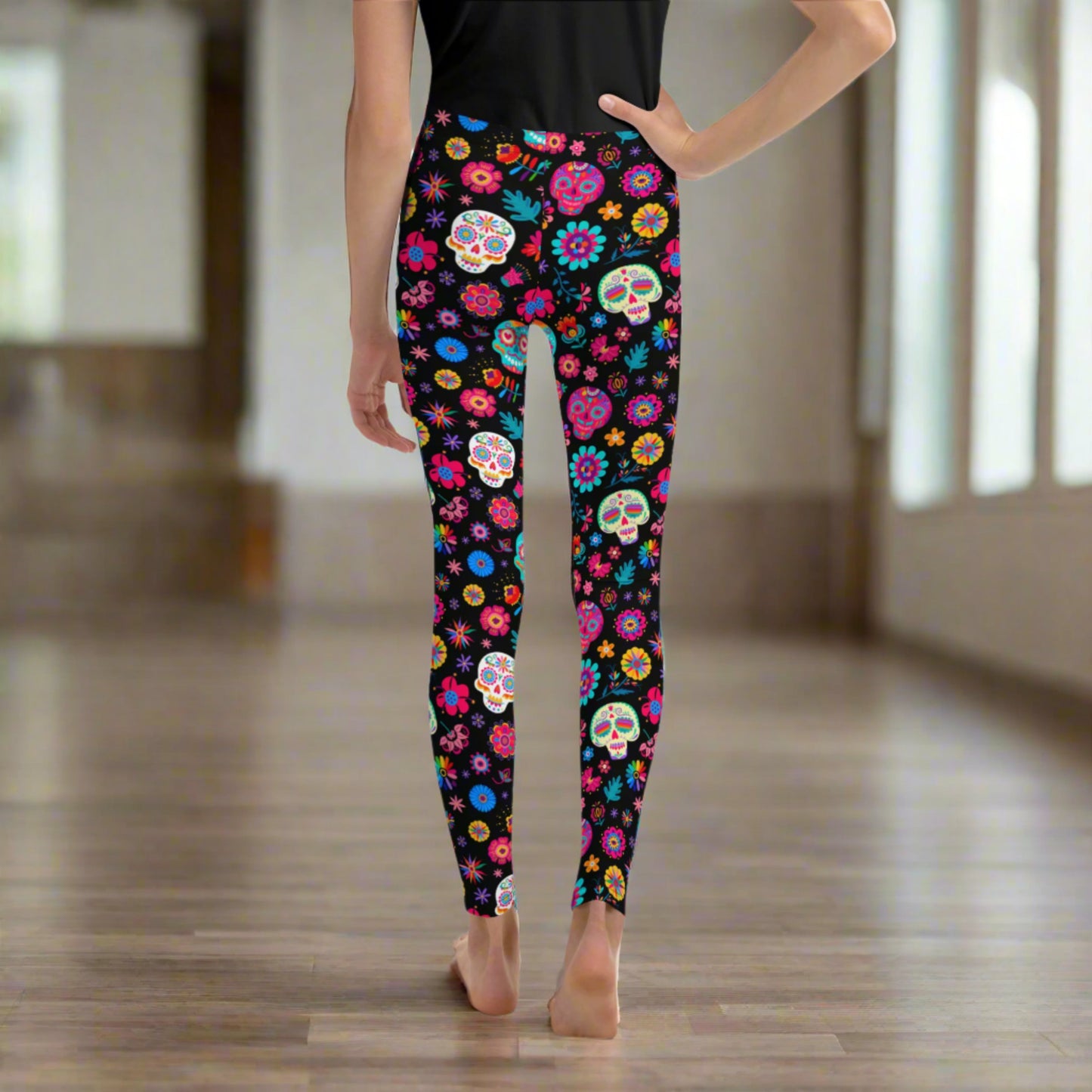These youth Día de los Muertos leggings are a vibrant choice for girls celebrating the season. With sugar skulls and marigolds printed on soft, stretchy fabric, they’re ideal for fall school days, parades, and family photos. Available in sizes 8–20, they complete a matching look with toddler and women’s leggings, perfect for honoring Day of the Dead traditions in style.