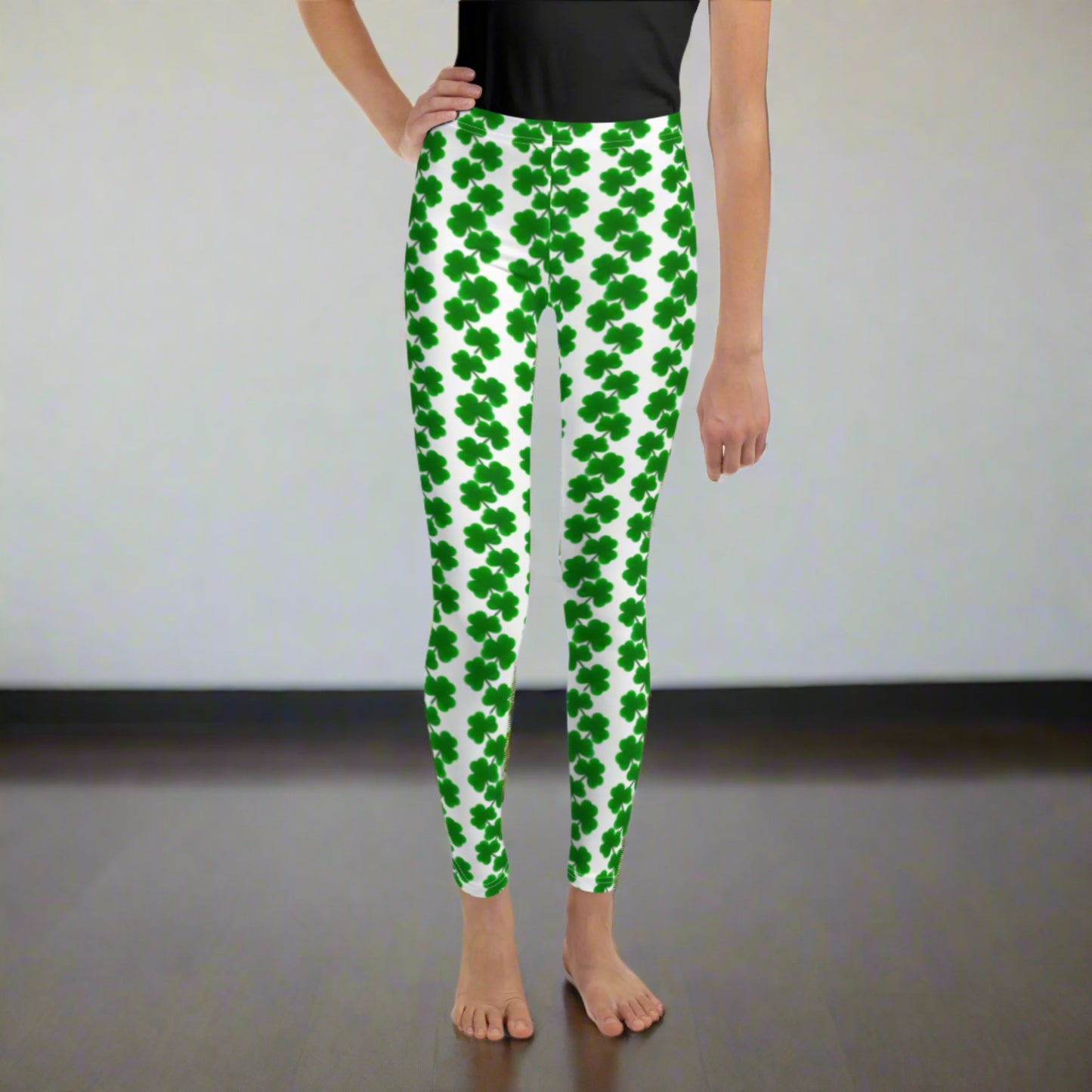 Image: St Patricks Day Shamrock Leggings in Tween and Teen Girls Sizes 8, 10, 12, 14, 16, 18, 20. These white yoga pants feature rows of four leaf clovers in a pattern down each leg, by jaecrece