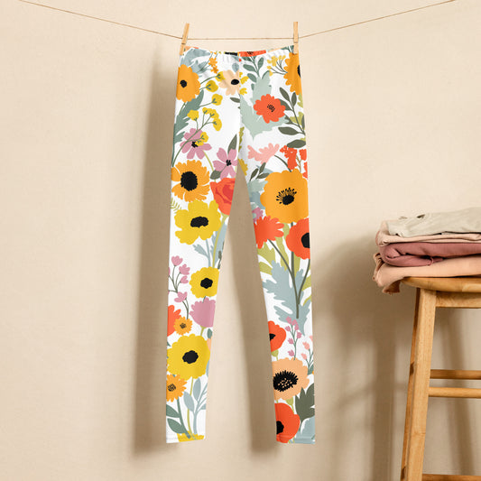 Image: Vibrant watercolor wildflower leggings for girls, tweens, and teens in sizes 8–20. These youth leggings feature a soft white background covered in colorful Texas-style wildflowers, perfect for spring and summer. Made with stretchy fabric, they are comfy for everyday wear, school, or outdoor fun. Part of a matching mommy and me collection for coordinated family looks. Ideal for Easter, photoshoots, or nature-inspired outfits, by jaecrece.