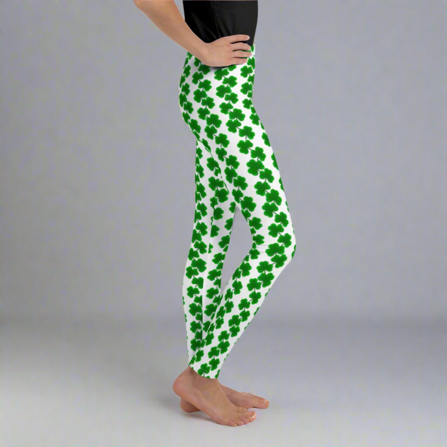 Image: St Patricks Day Shamrock Leggings in Tween and Teen Girls Sizes 8, 10, 12, 14, 16, 18, 20. These white yoga pants feature rows of four leaf clovers in a pattern down each leg, by jaecrece