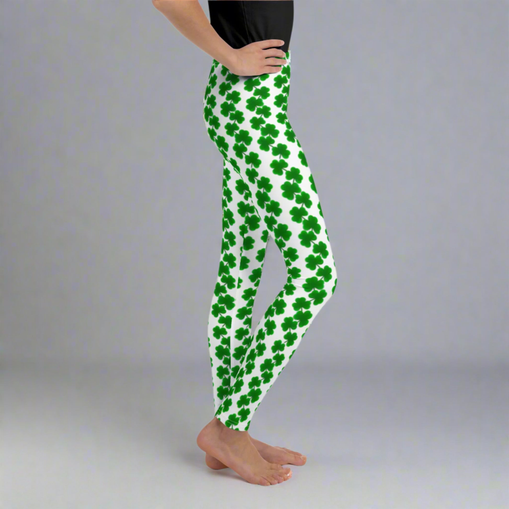 Image: St Patricks Day Shamrock Leggings in Tween and Teen Girls Sizes 8, 10, 12, 14, 16, 18, 20.These shamrock leggings for girls come in youth sizes 8–20 and are ideal for celebrating St. Patrick’s Day in style. Set on a white base, green shamrocks form chain-like patterns down the legs for a whimsical, festive look. Comfortable and flexible with four-way stretch, these girls’ leggings are a fun addition to Irish holiday outfits, classroom parties, or themed family photoshoots.