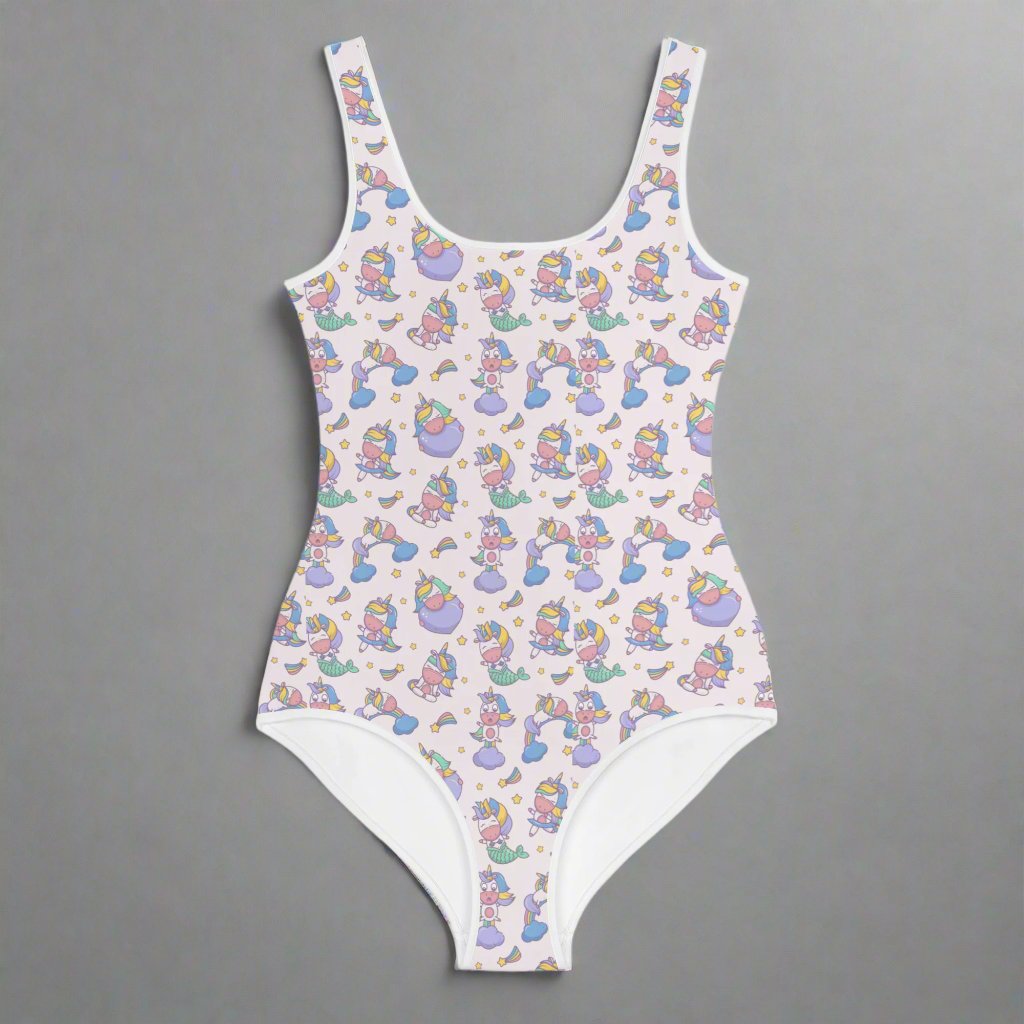 Image: Child bathing suit in toddler and girl sizes 8-20, featuring a pink background with a cute Kawaii whimsical creature pattern of unicorn mermaids, rainbows and stars. Perfect as a Christmas gift, birthday present, or for your childs next pool party, by jaecrece