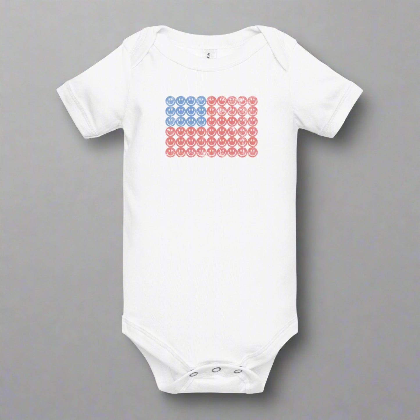 White baby bodysuit onesie. The graphic is an American flag, made up of Blue and Red Vintage smiley faces, by jaecrece.com