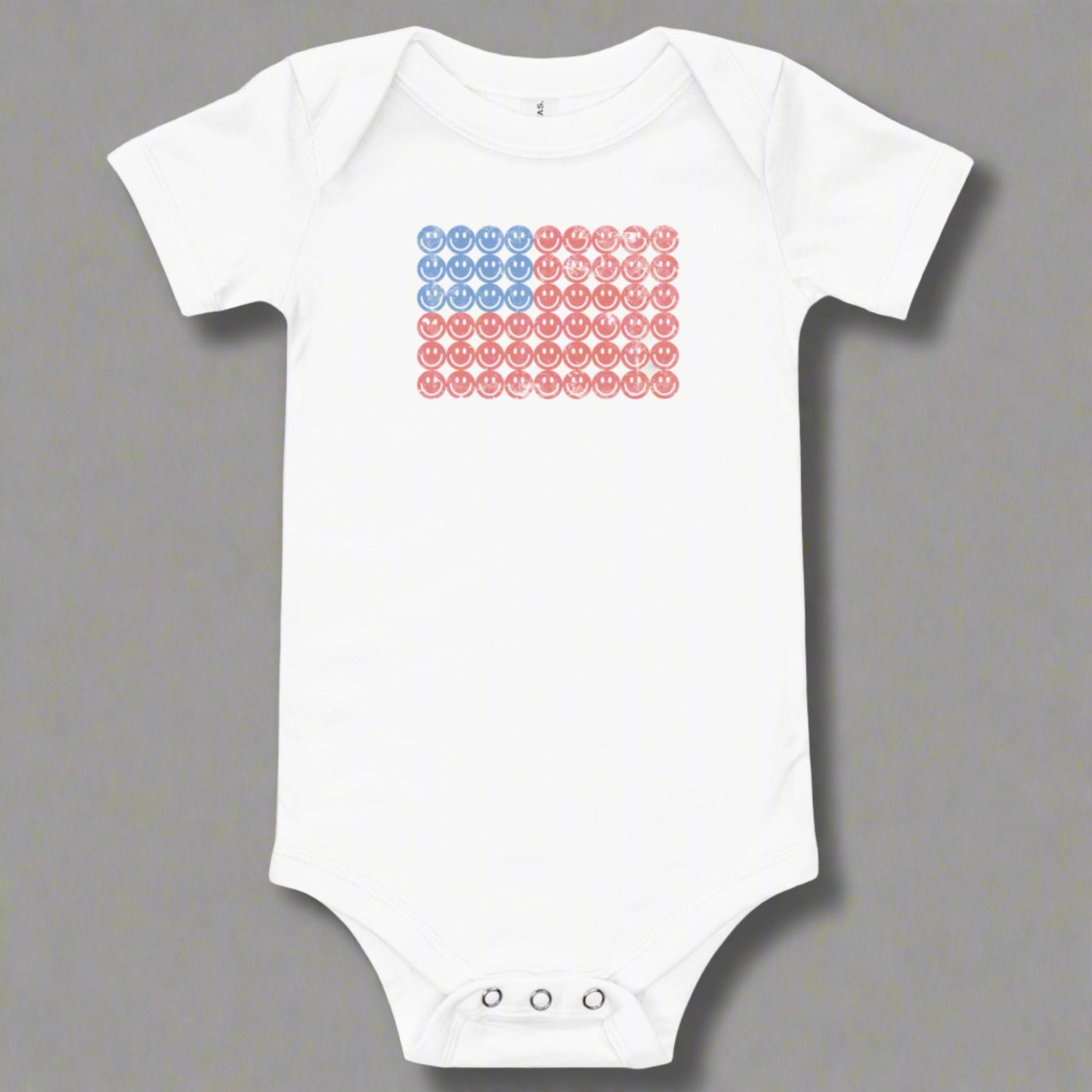 White baby bodysuit onesie. The graphic is an American flag, made up of Blue and Red Vintage smiley faces, by jaecrece.com