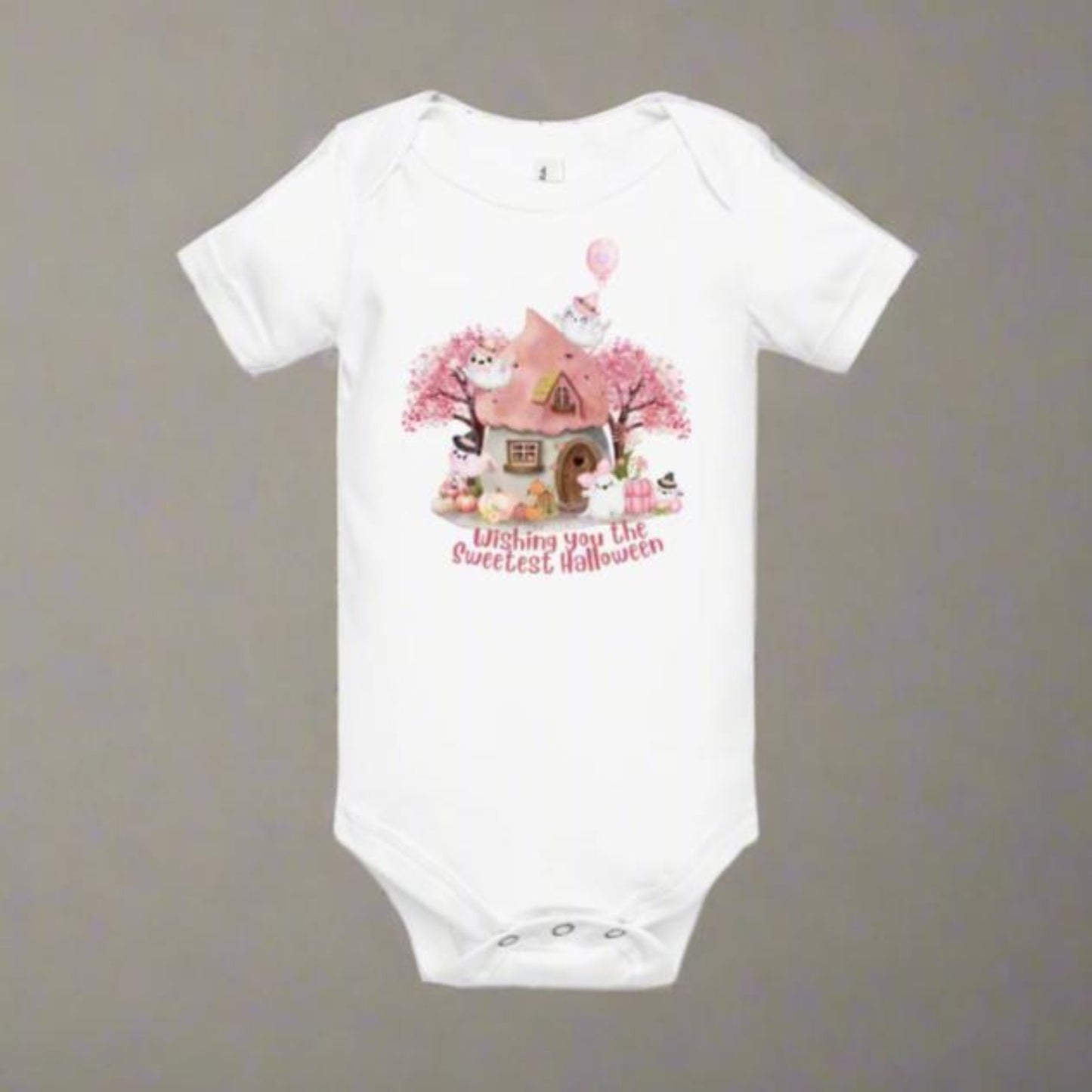 Image: Fall fun begins with this sweet pink Halloween baby bodysuit, perfect for baby girls who love magic and mystery. Featuring cute pastel ghosts, a pink pumpkin patch, and a cozy cottage, it’s an ideal first Halloween outfit, soft enough for all day wear and adorable enough for festive photos, by jaecrece.