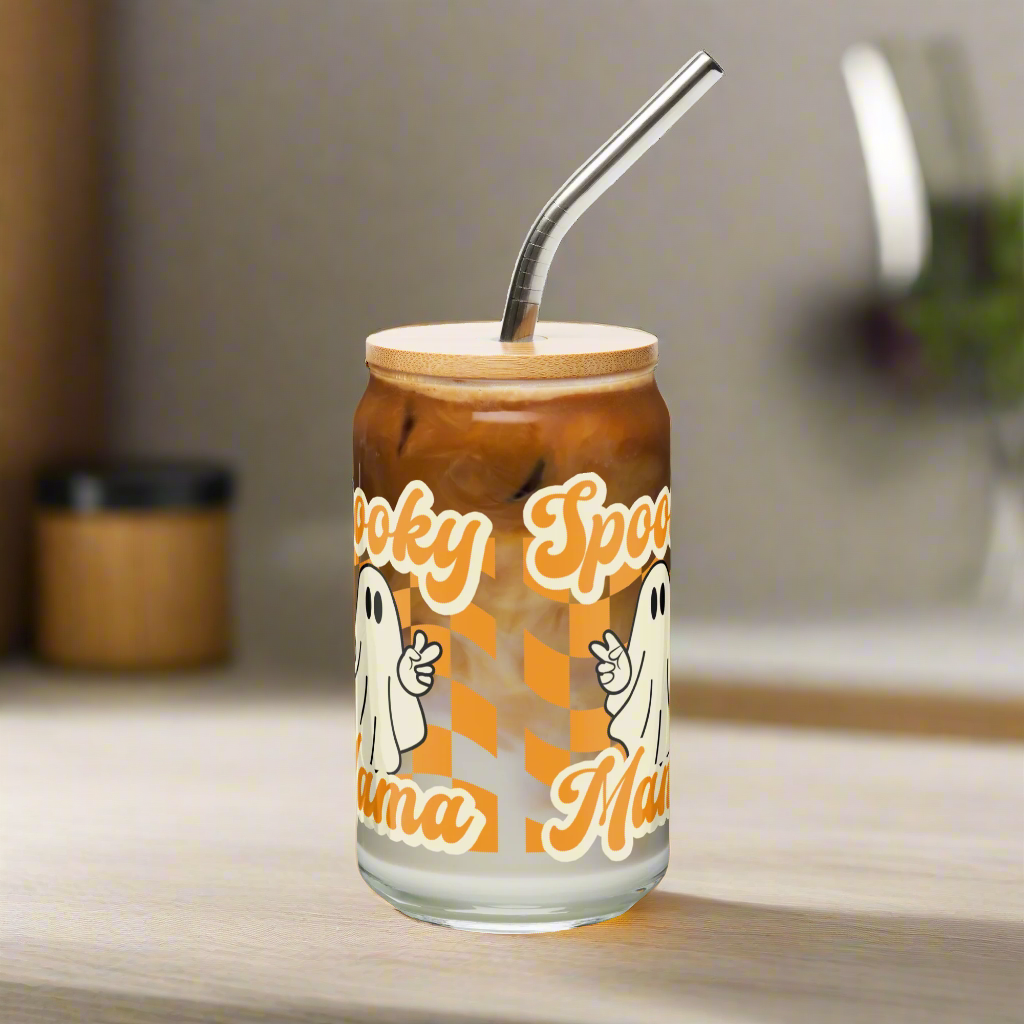 Cute Ghost Halloween Fall 16 oz Sipper Glass Funny Halloween Gift for Mom Spooky Mama Halloween Glass Coffee Cup, featuring a orange checkerboard design with a white ghost giving the peace sign and the text Spooky Mama in orange and white cursive bubble font by jaecrece.com