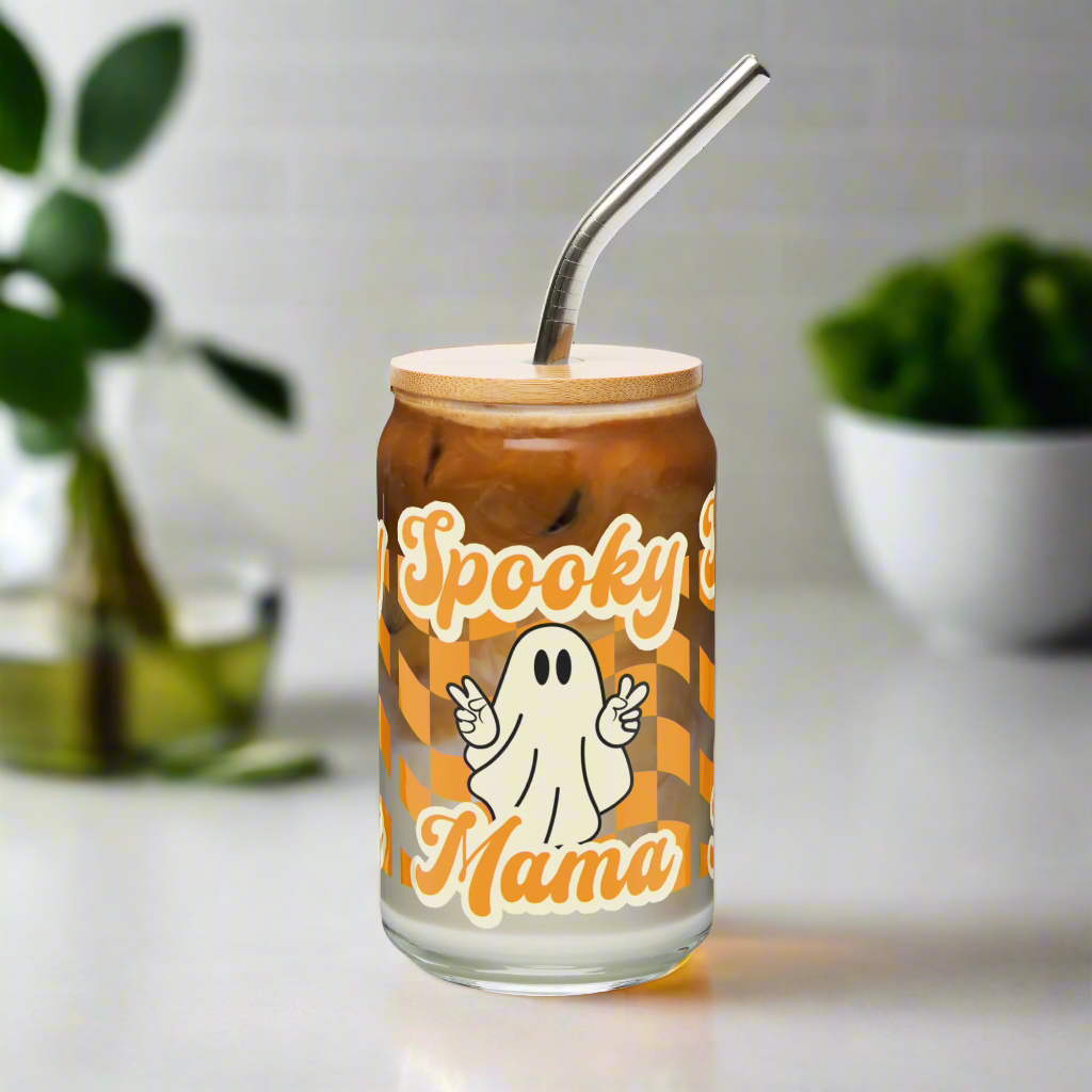 Cute Ghost Halloween Fall 16 oz Sipper Glass Funny Halloween Gift for Mom Spooky Mama Halloween Glass Coffee Cup, featuring a orange checkerboard design with a white ghost giving the peace sign and the text Spooky Mama in orange and white cursive bubble font by jaecrece.com