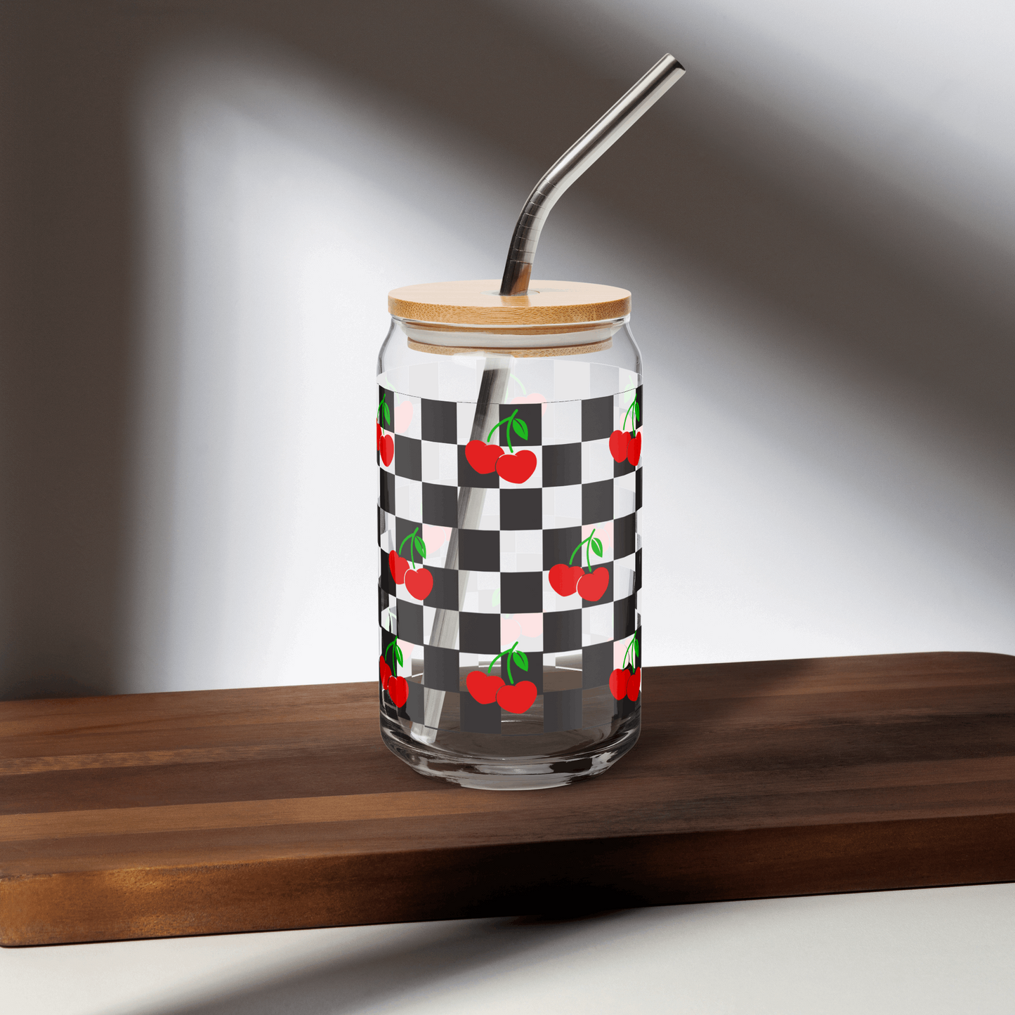 Cherry Checkerboard 16 oz Sipper Glass with wooden lid and metal straw, featuring a black checkboard pattern with red cherries and green stems. Perfect travel mug for iced coffee or mocktails, by jaecrece
