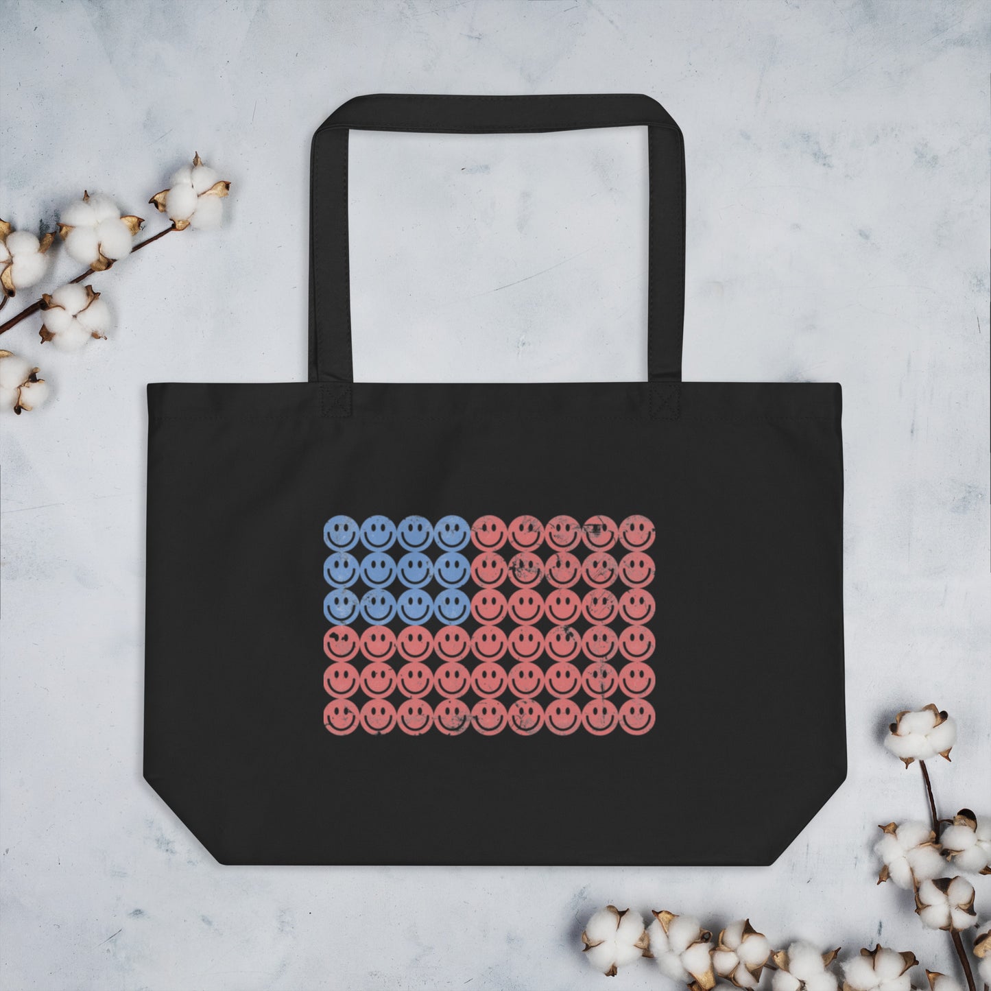 Eco-friendly black tote bag made from 100% organic cotton with a playful American flag graphic designed entirely from retro smiley faces. Perfect for Independence Day, parades, or everyday errands, this large tote combines nostalgic style with sustainable function. Great for patriotic gifting or summer accessory lovers. Keywords: smiley face USA tote, organic cotton Fourth of July bag, vintage American flag tote, reusable patriotic tote.