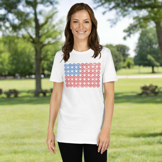 This white adult t-shirt features a retro American flag graphic made of smiley faces, blending patriotic flair with playful vintage style. Made from soft, organic cotton, this eco-friendly Fourth of July shirt is perfect for barbecues, fireworks, parades, or casual summer wear. Ideal for those who love retro American flag designs, minimalist patriotic fashion, and sustainable summer style with a fun twist.