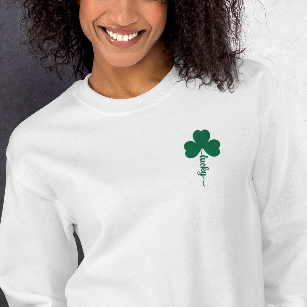 Image: St Patricks Day Emboidered Shamrock Lucky Women's Sweatshirt. This white crewneck pullover has embroidered green four leaf clover, and stem of the clover spells Lucky. This St. Pattys Day pullover sweater is also available in childrens sizes, for family matching opportunities, by jaecrece