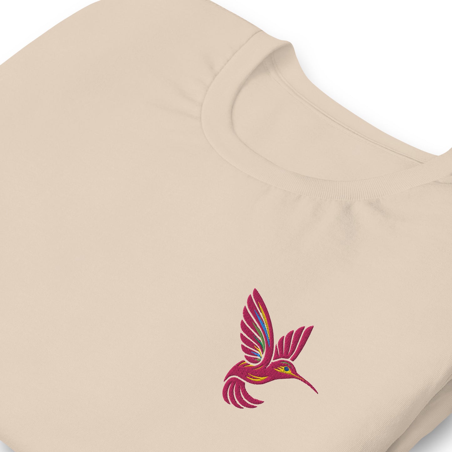 Cream colored hummingbird embroidered shirt, with a bright pink bird on the chest. Ideal for mix-and-match family outfits, nature lovers, or sustainable shoppers seeking embroidered detail, breathable cotton, and inclusive XS–5XL sizing. A standout piece for spring or gifting.