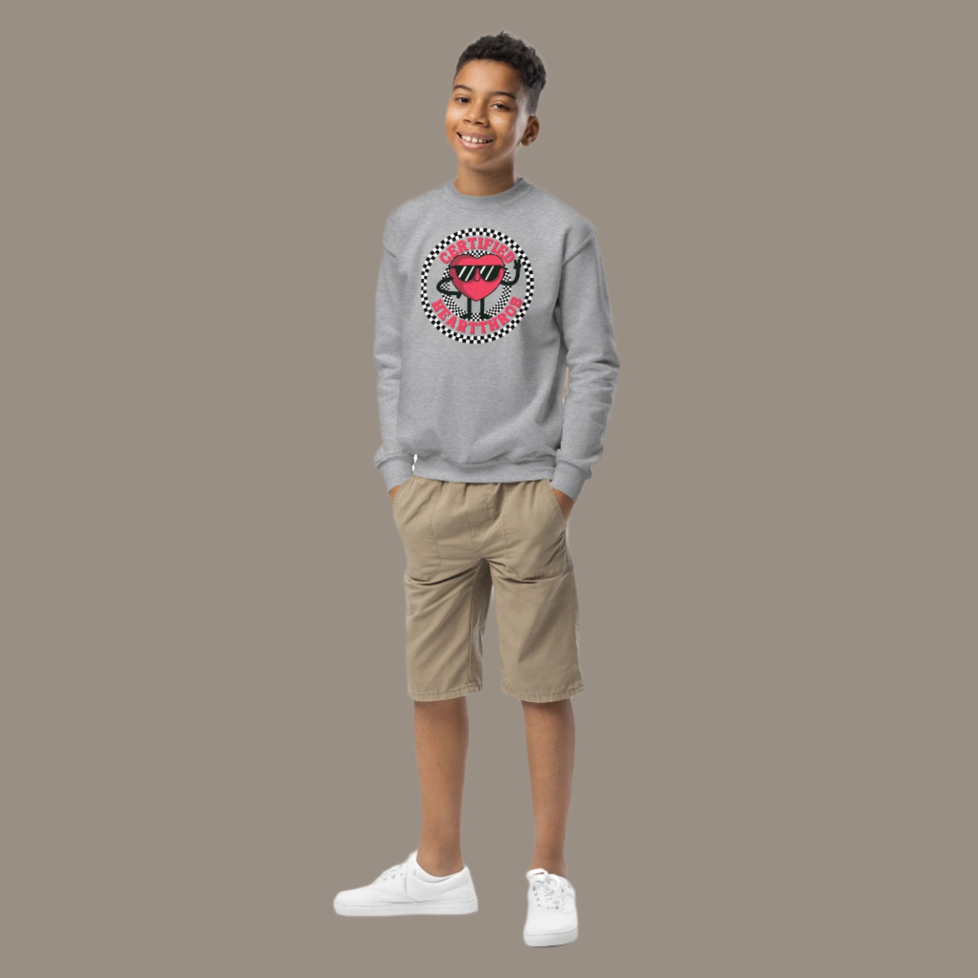 Image: Certified Heartthrob Sweatshirt. This Valentines Day sweater for boys or girls is available in white or gray. It features a checker pattern ring, with a cartoon heart man wearing sunglasses, with the text Certified Heartthrob, by jaecrece