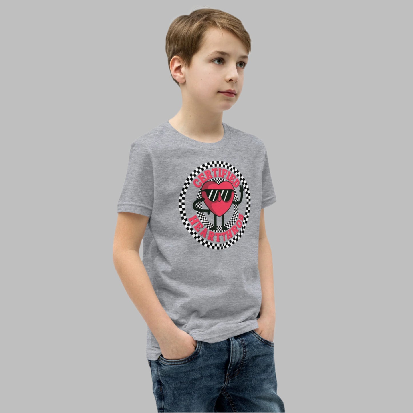 Image: Certified Heartthrob Tshirt. This Valentines Day tee for boys or girls is available in white or gray. It features a checker pattern ring, with a cartoon heart man wearing sunglasses, with the text Certified Heartthrob, by jaecrece