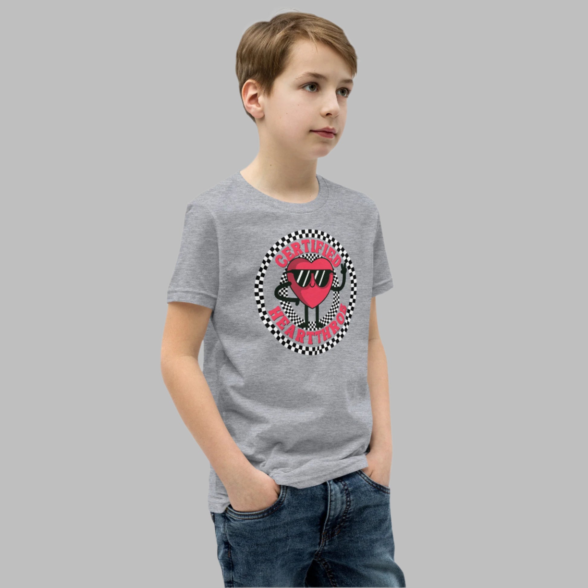 Image: Certified Heartthrob Tshirt. This Valentines Day tee for boys or girls is available in white or gray. It features a checker pattern ring, with a cartoon heart man wearing sunglasses, with the text Certified Heartthrob, by jaecrece