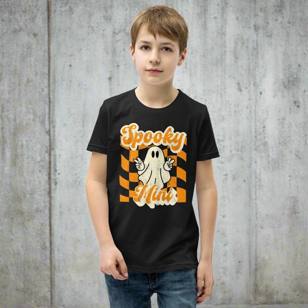 Spooky Mini Unisex Youth shirt, for girls and boys, featuring an orange checkerboard pattern with a cute ghost and the text Spooky Mini, by jaecrece