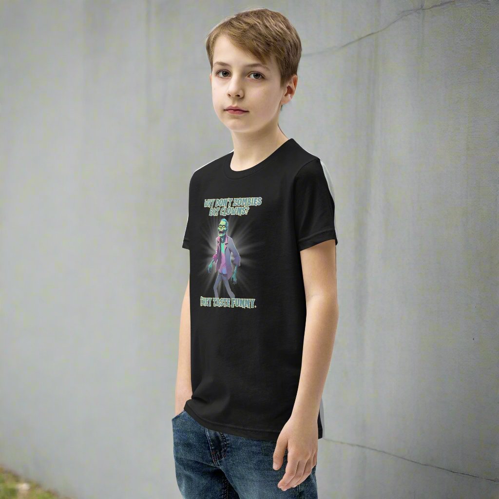 Halloween Zombie Joke Kids T-Shirt. This is a black tee with a picture of a laughing cartoon zombie. The text reads "Why don't zombies eat clowns? They taste funny", by jaecrece.com