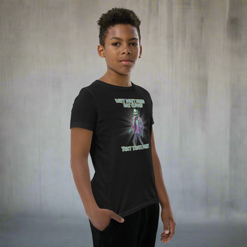 Halloween Zombie Joke Kids T-Shirt. This is a black tee with a picture of a laughing cartoon zombie. The text reads "Why don't zombies eat clowns? They taste funny", by jaecrece.com