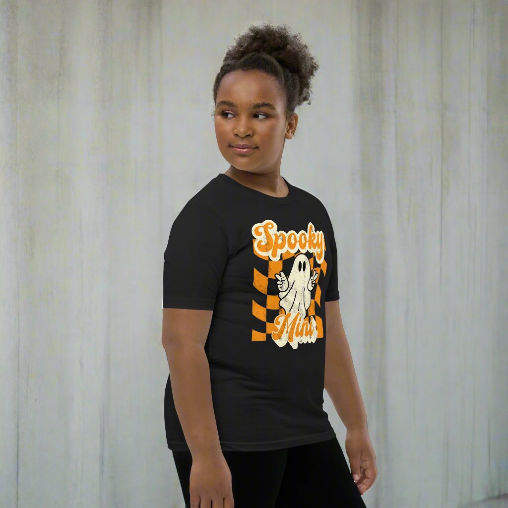 Spooky Mini Unisex Youth shirt, for girls and boys, featuring an orange checkerboard pattern with a cute ghost and the text Spooky Mini, by jaecrece