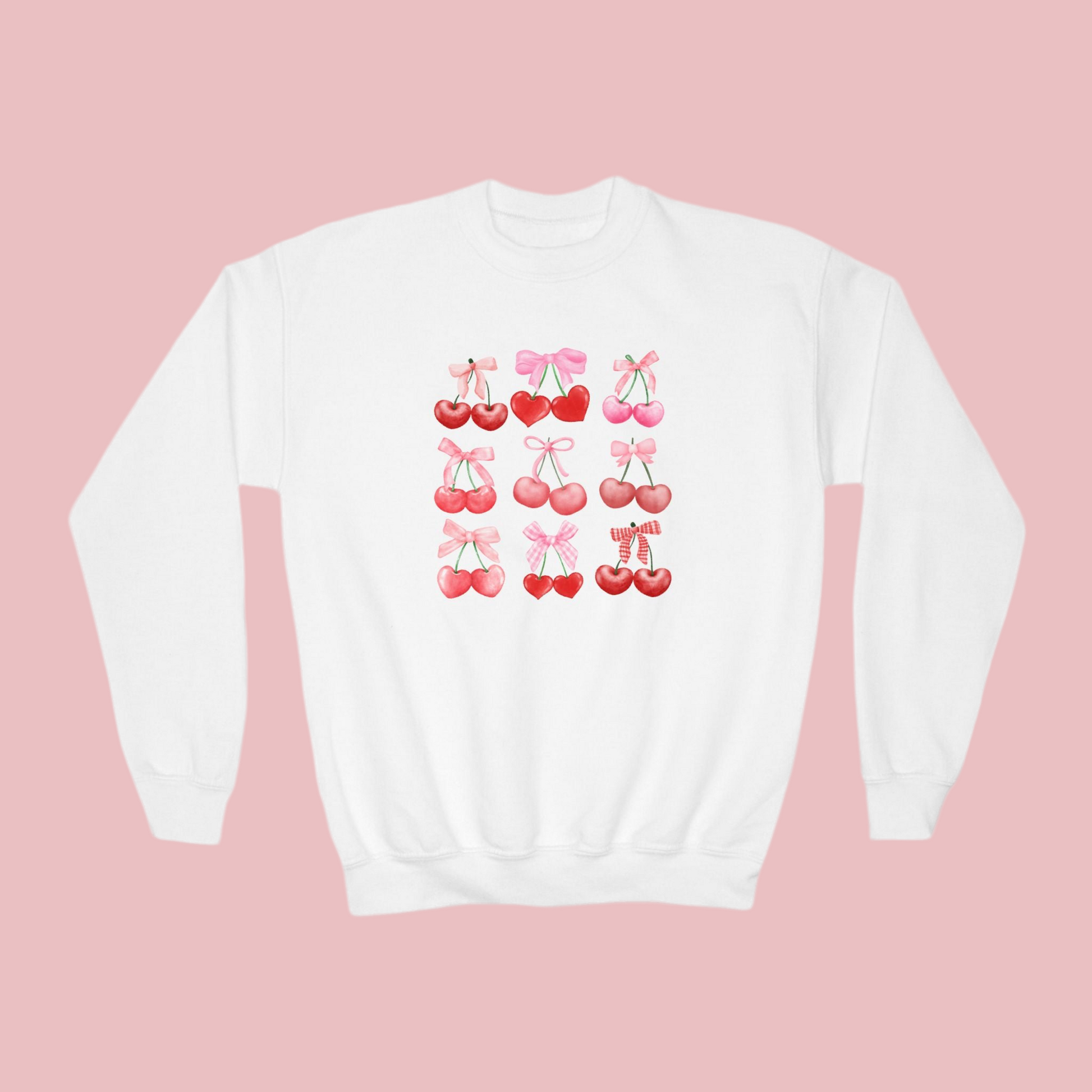 Image: Cherry Bow Girls Sweatshirt, available in Hot pink, White and dark gray. This coquette aesthetic shirt features 9 different cherries with bows, making a large soft girly graphic. Makes a great Valentines gift for toddlers and little girls, by jaecrece