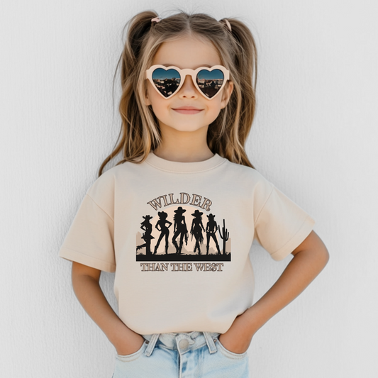 Wilder than the West youth girls shirt in natural features five cowgirl silhouettes in front of a desert sunset with cactus. This western silhouette tee comes in youth sizes S–XL and is perfect for rodeos, state fairs, and country music festivals. Part of a mommy and me match set for toddlers, girls, and women, this graphic wear tee is ideal for southern girls, horse lovers, and coquette bachelorette trip vibes.

