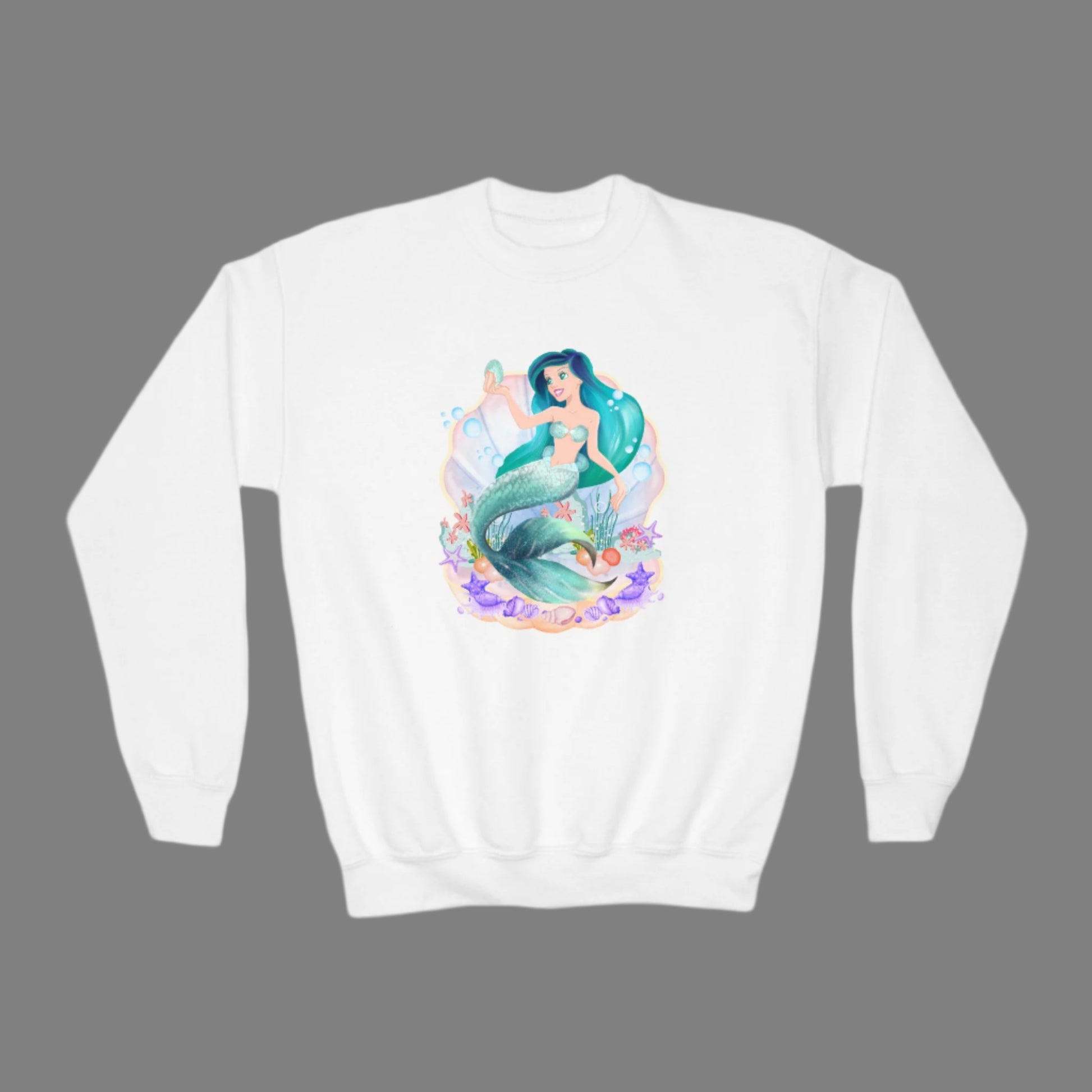 Image: Mermaid Sweatshirt for Little Girls. Pullover crewneck sweatshirt features a mermaid with blue hair and scales, swimming in a shell, with bubbles and seashells. This mermaidcore sweater is available in white, navy and hot pink, by jaecrece