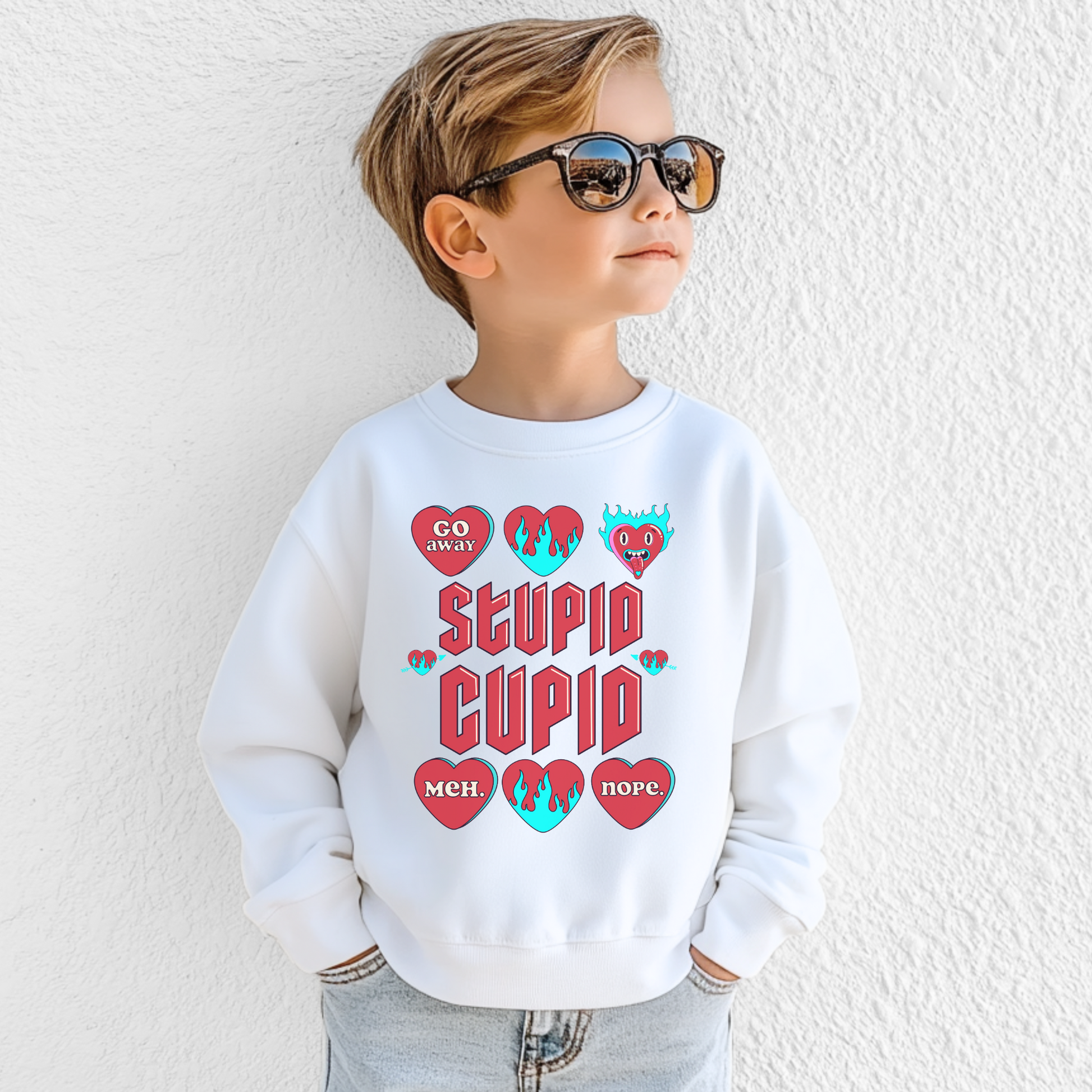 Image: Stupid Cupid Anti Valentines Day T-shirt for Kids. This sweatshirt is for girls and boys with red 90s style text that reads Stupid Cupid, with conversation hearts that are on fire, or say Go Away, Meh, Nope. Great for school party, by jaecrece