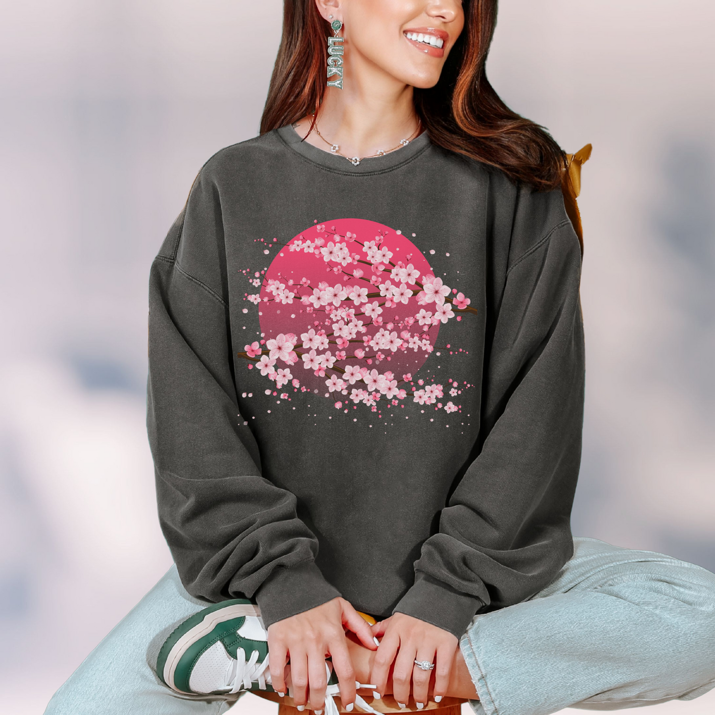 Image: Japanese Cherry Blossom Womens Comfort Colors 1466 sweatshirt featuring a serene pink moon design with delicate Japanese cherry blossom (sakura) branches. This cozy, vintage-washed crewneck offers a relaxed fit, perfect for casual wear. Inspired by Japanese aesthetics, this sakura sweatshirt captures the beauty of nature and the fleeting elegance of cherry blossoms under a moonlit sky. Ideal for spring outfits, hanami festivals, or anyone who loves Japanese-inspired fashion and celestial designs.