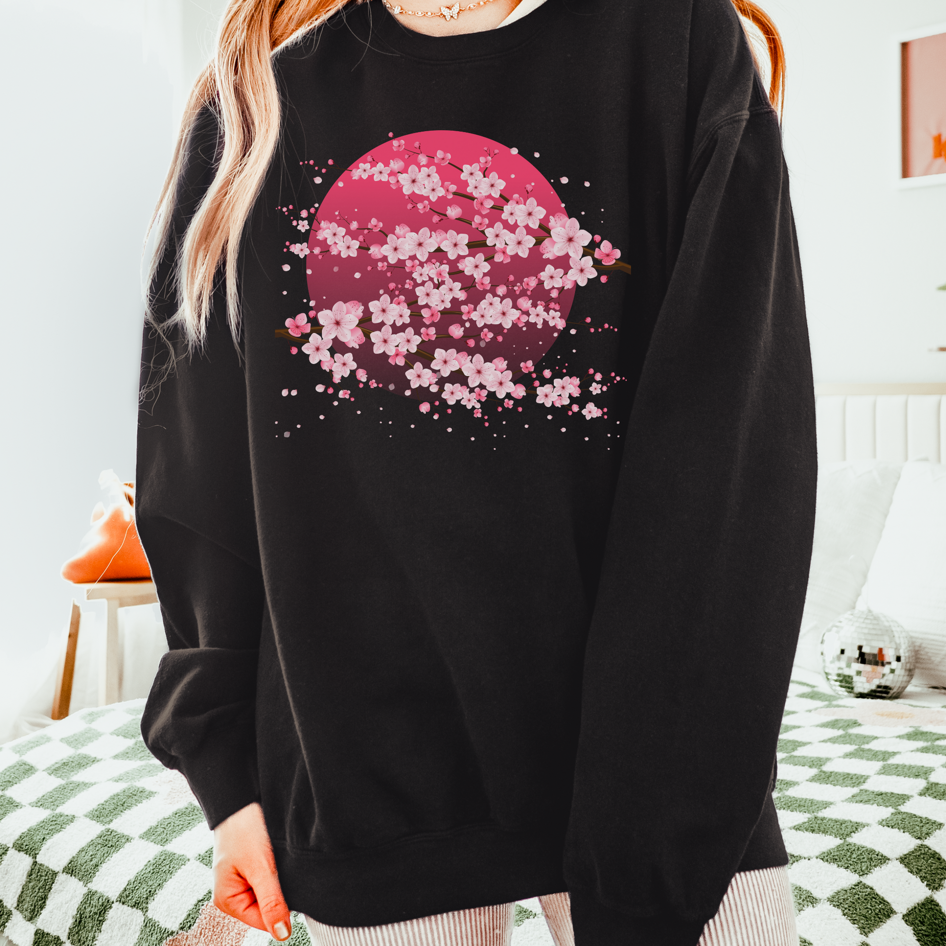 Image: Japanese Cherry Blossom Womens Comfort Colors 1466 sweatshirt featuring a serene pink moon design with delicate Japanese cherry blossom (sakura) branches. This cozy, vintage-washed crewneck offers a relaxed fit, perfect for casual wear. Inspired by Japanese aesthetics, this sakura sweatshirt captures the beauty of nature and the fleeting elegance of cherry blossoms under a moonlit sky. Ideal for spring outfits, hanami festivals, or anyone who loves Japanese-inspired fashion and celestial designs.