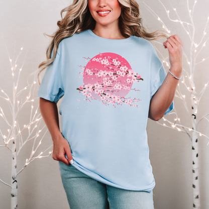 Image: A pink cherry blossom t-shirt featuring a delicate sakura tree design. The soft, durable fabric offers comfort, while the classic fit makes it versatile for any occasion. Perfect for springtime celebrations, Japanese aesthetic lovers, and those who appreciate kawaii fashion. Ideal as a gift for teens and adults. 