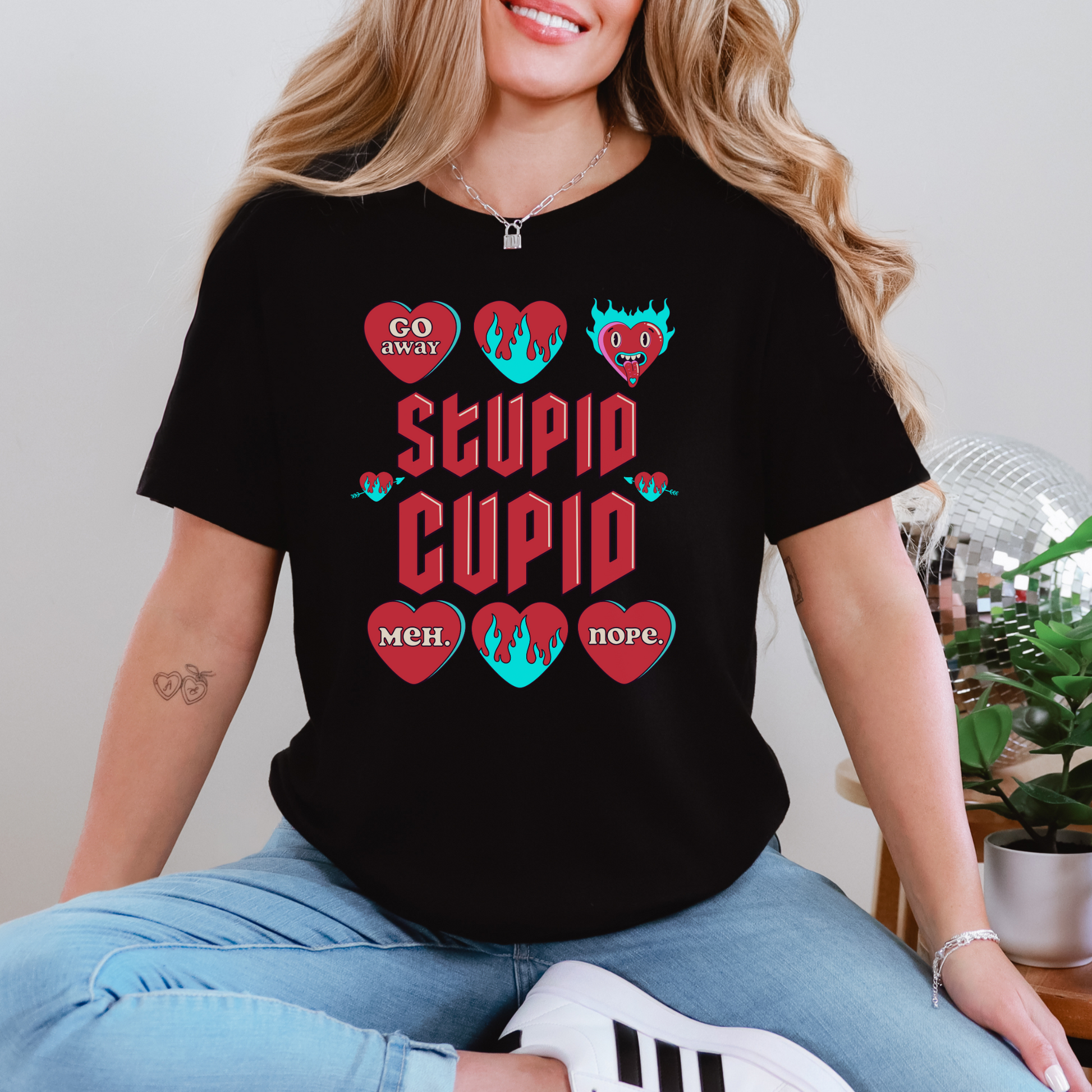 Image: Stupid Cupid Anti Valentines Day T-shirt, Unisex adult breakup shirt- this tee has large red 90s style text that reads Stupid Cupid, surrounded by conversation hearts that are on fire, or say Go Away, Meh, Nope. Great for divorce, by jaecrece